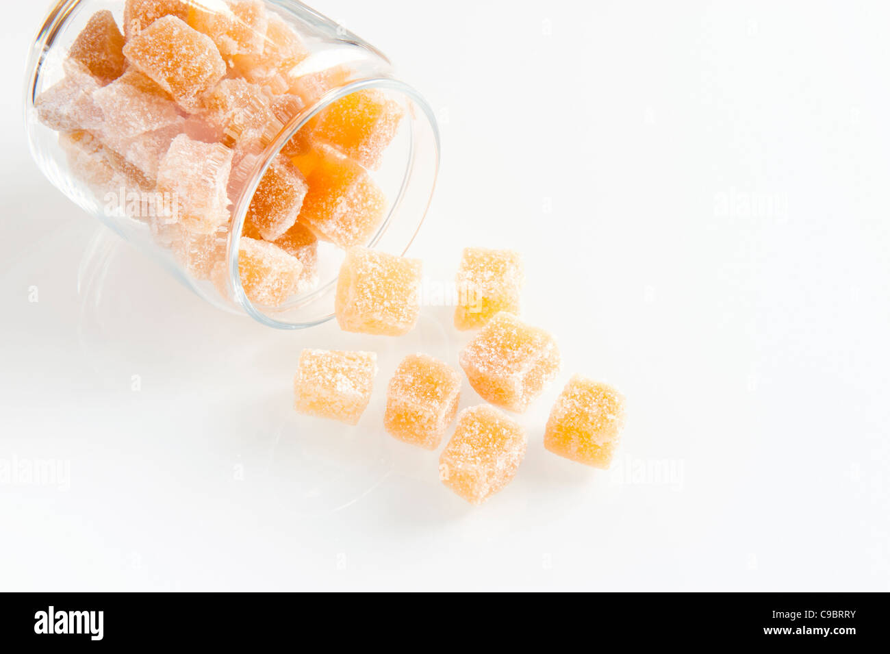 Cubes of Crystallized Ginger Spilling Out of a Glass Storage Jar Stock Photo