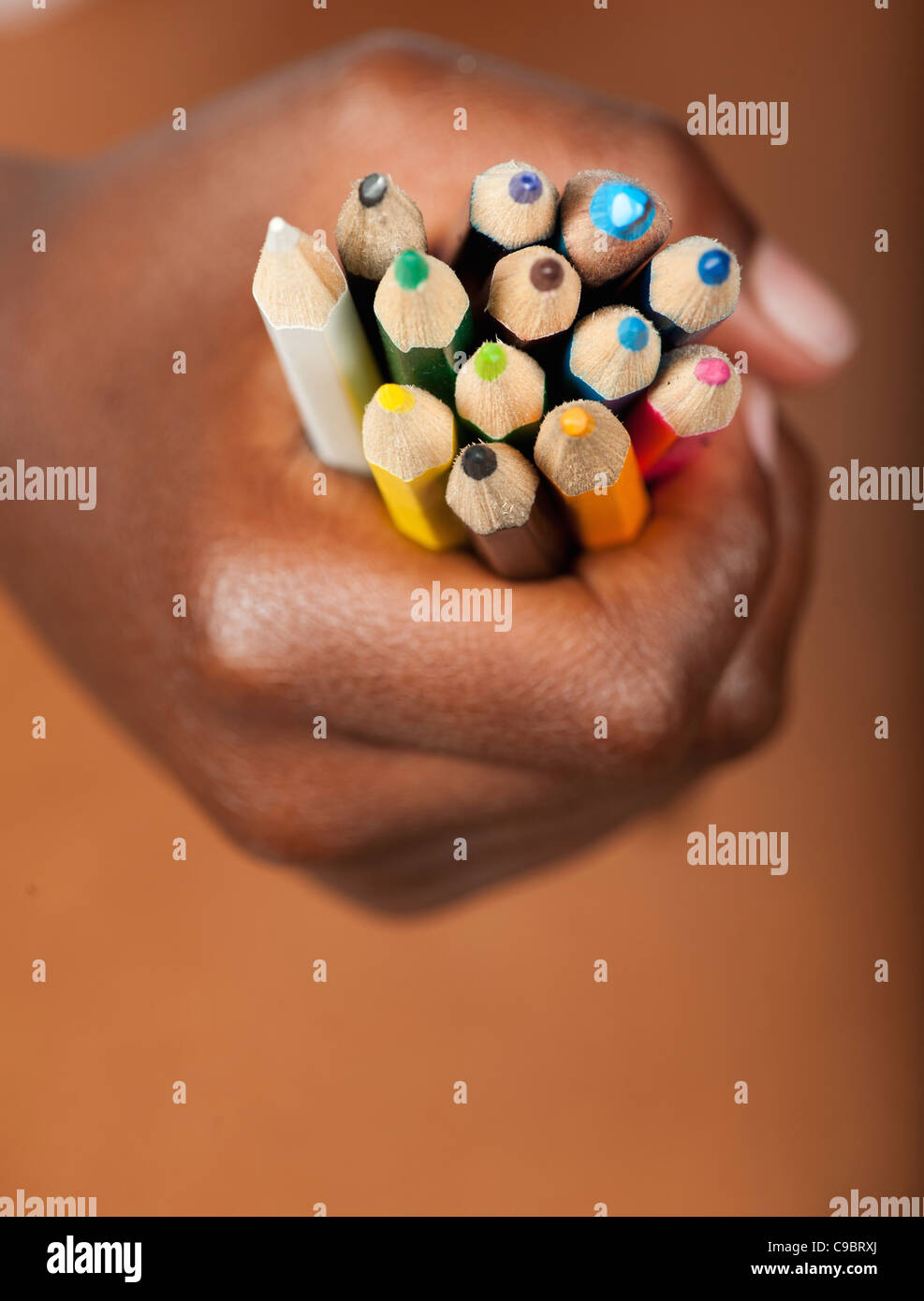 Childs hand gripping colored pencils, Johannesburg, Gauteng Province, South Africa Stock Photo
