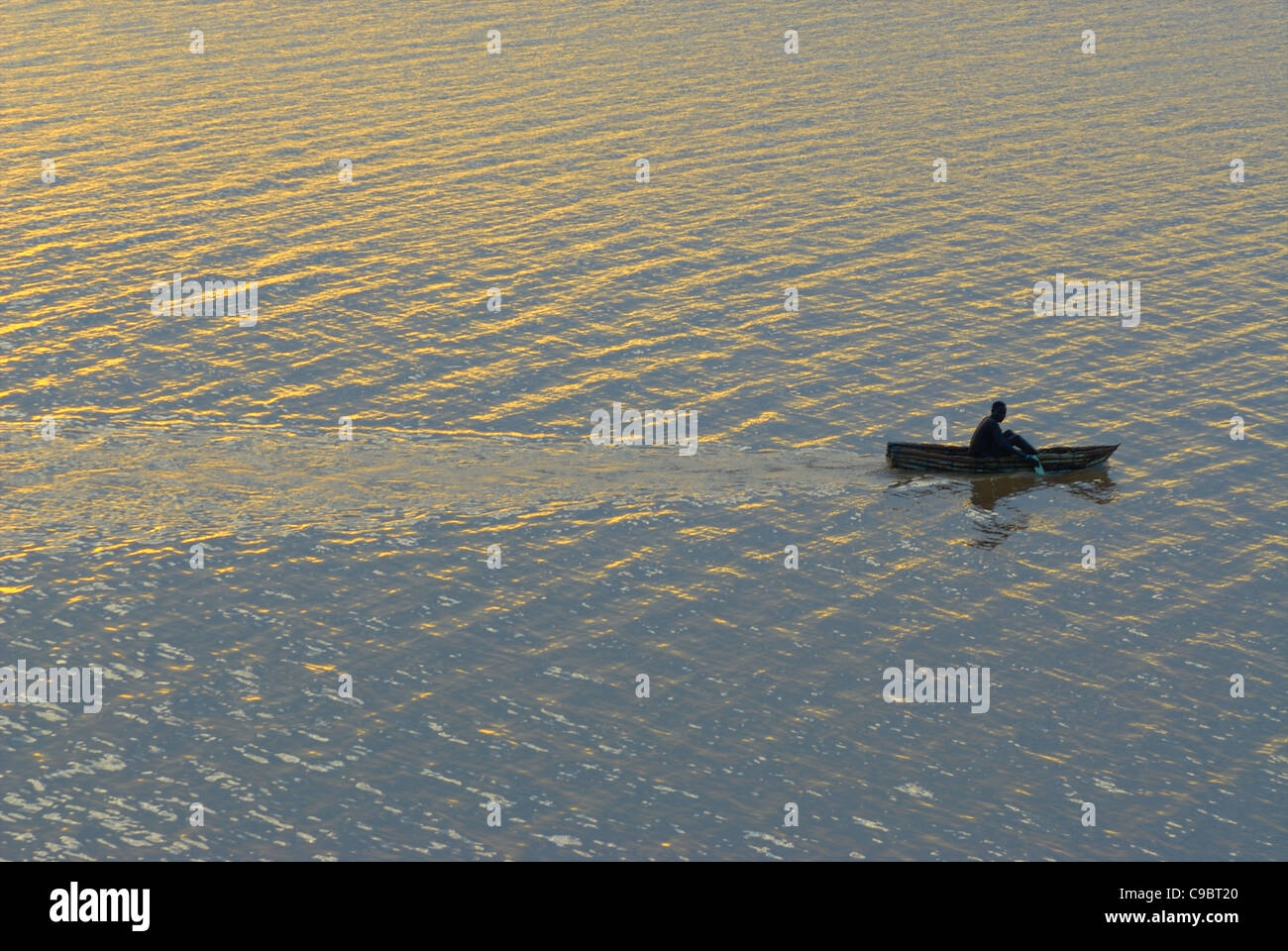 Njemps Fishman leaves early in the morning on his handmade reed boat to go fishing, Baringo, Kenya. Stock Photo
