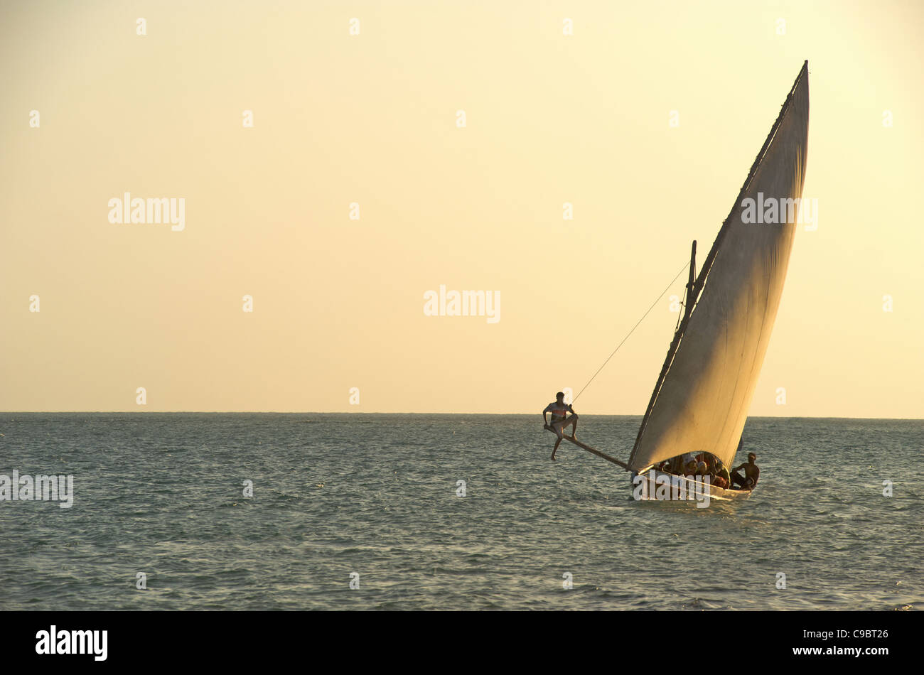 Sailboat on the open ocean at sunset Stock Photo