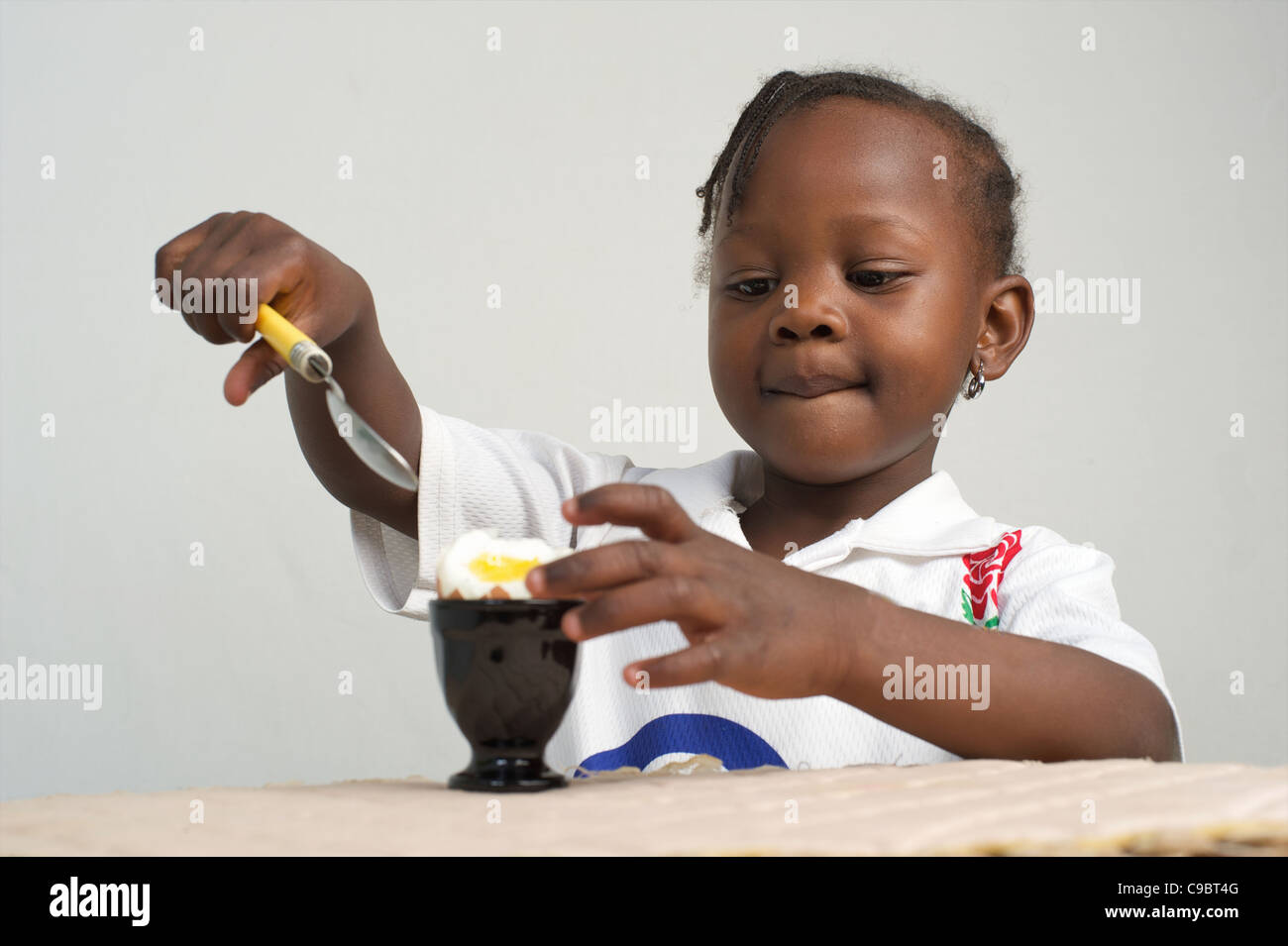 Young Kenyan girl eating boiled egg, Nairobi, Kenya Stock Photo
