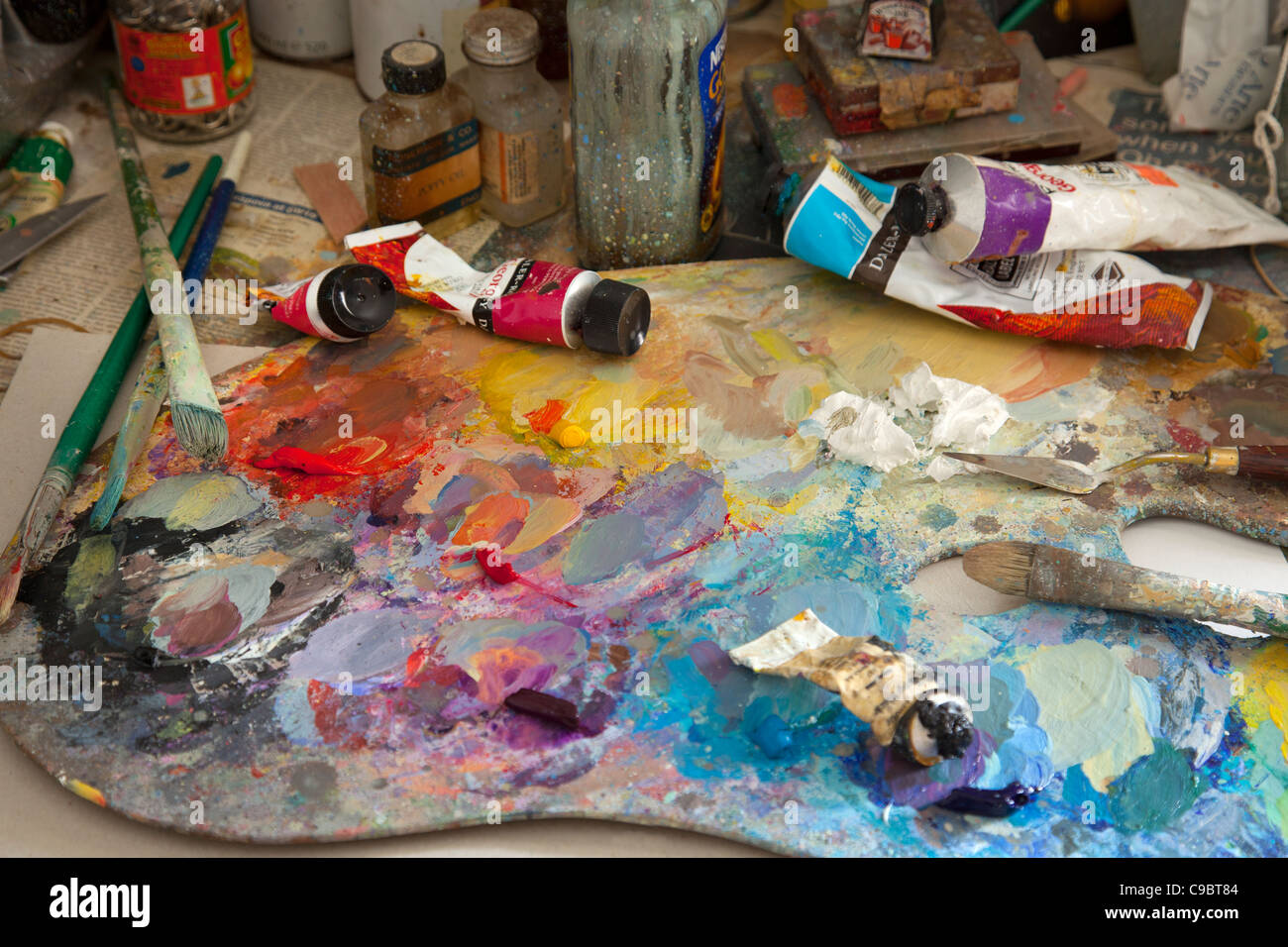 colorful artists Paint oil palette with brushes, knife, spatula, tube oils and jars Stock Photo