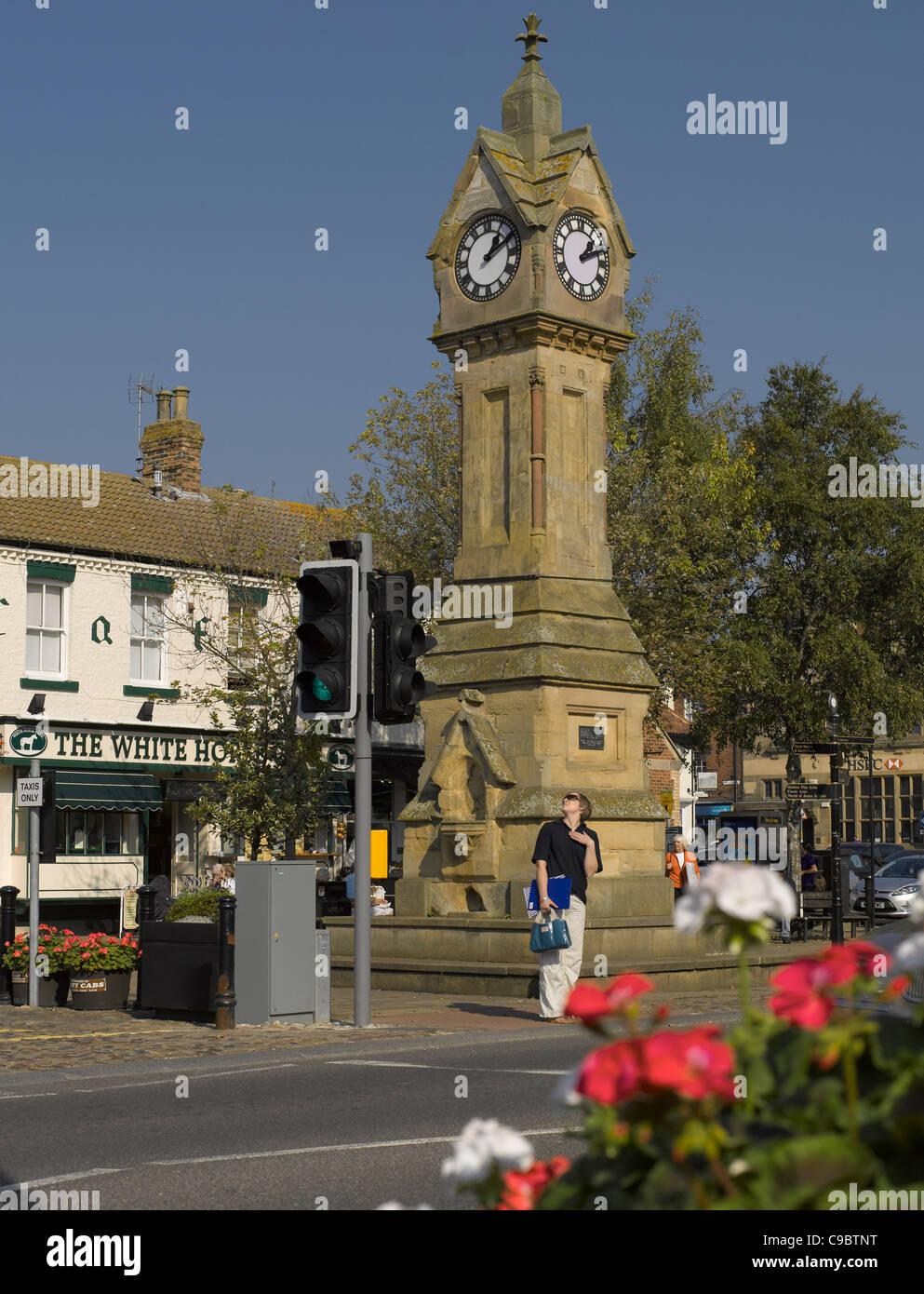 Waiting to cross the road near the Clock Tower in Market Place Thirsk North Yorkshire England UK United Kingdom GB Great Britain Stock Photo