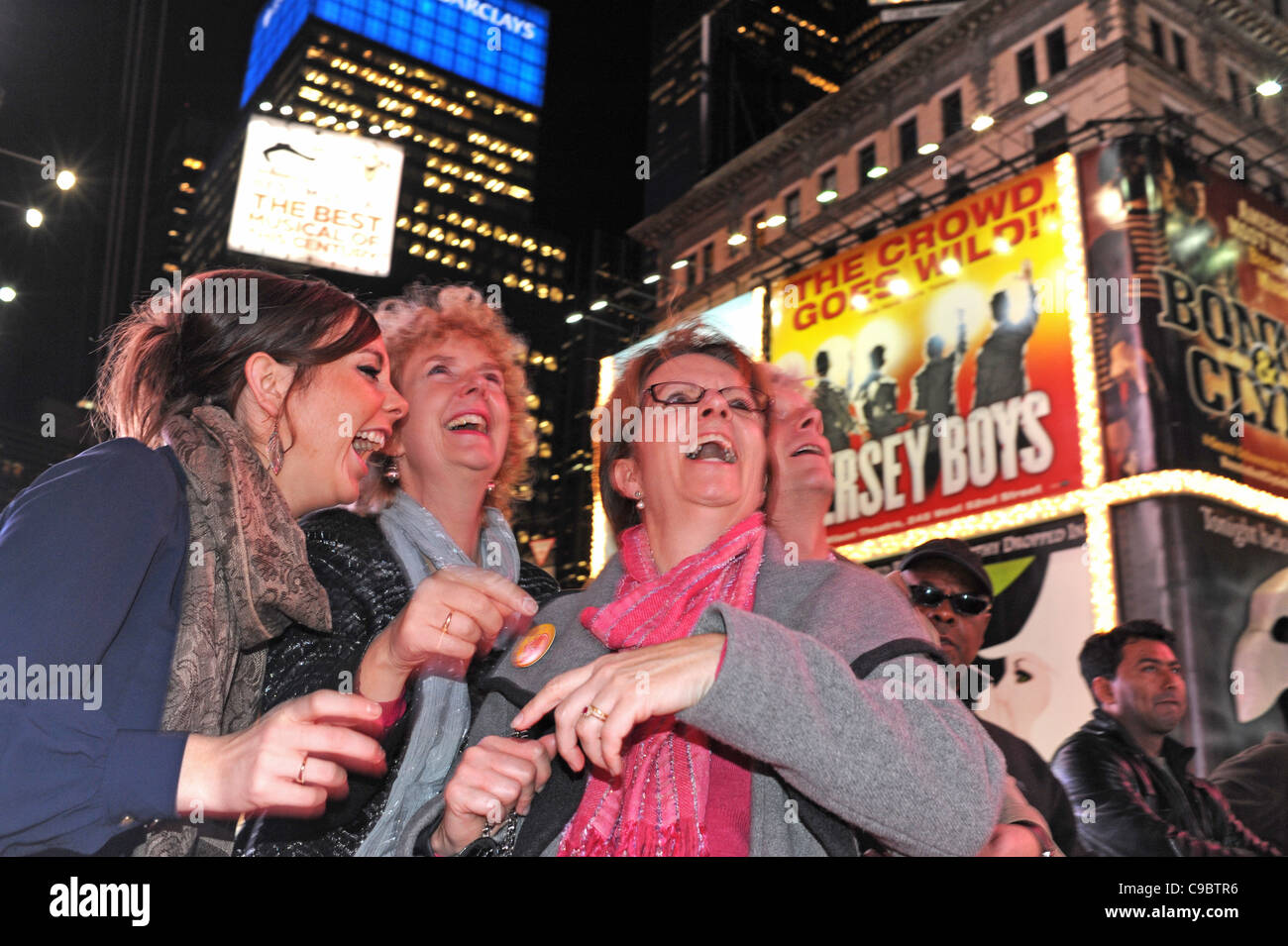 Women laughing Christmas shopping in Times Square Midtown Manhattan New York NYC USA America Stock Photo