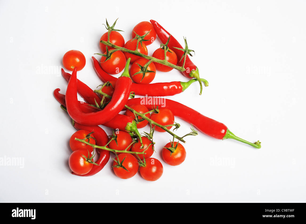 Cherry Tomatoes and red hot chilli peppers On white Background Stock Photo
