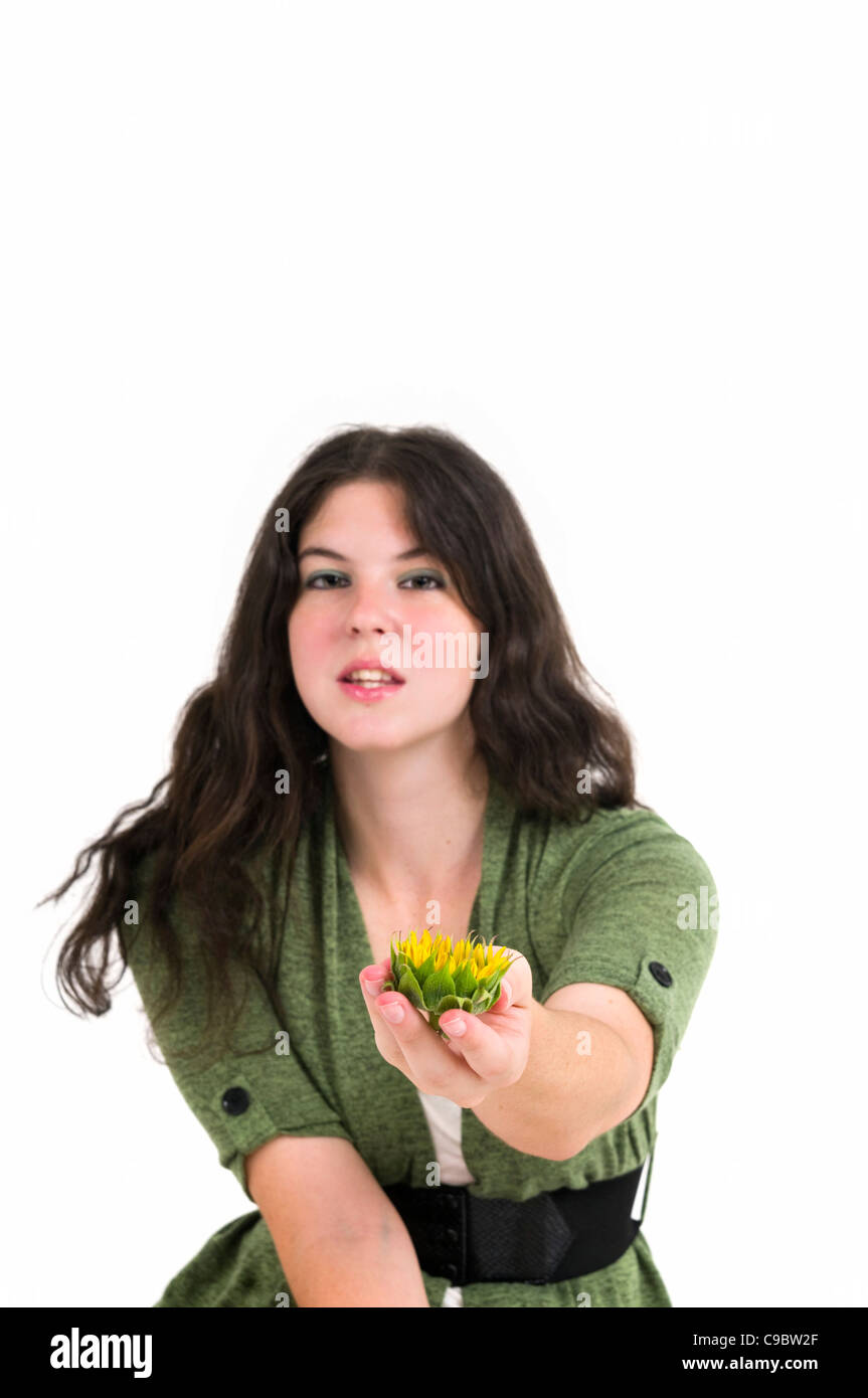 Young female teen offers the viewer a sunflower in the palm of her hand. Focus on flower Stock Photo