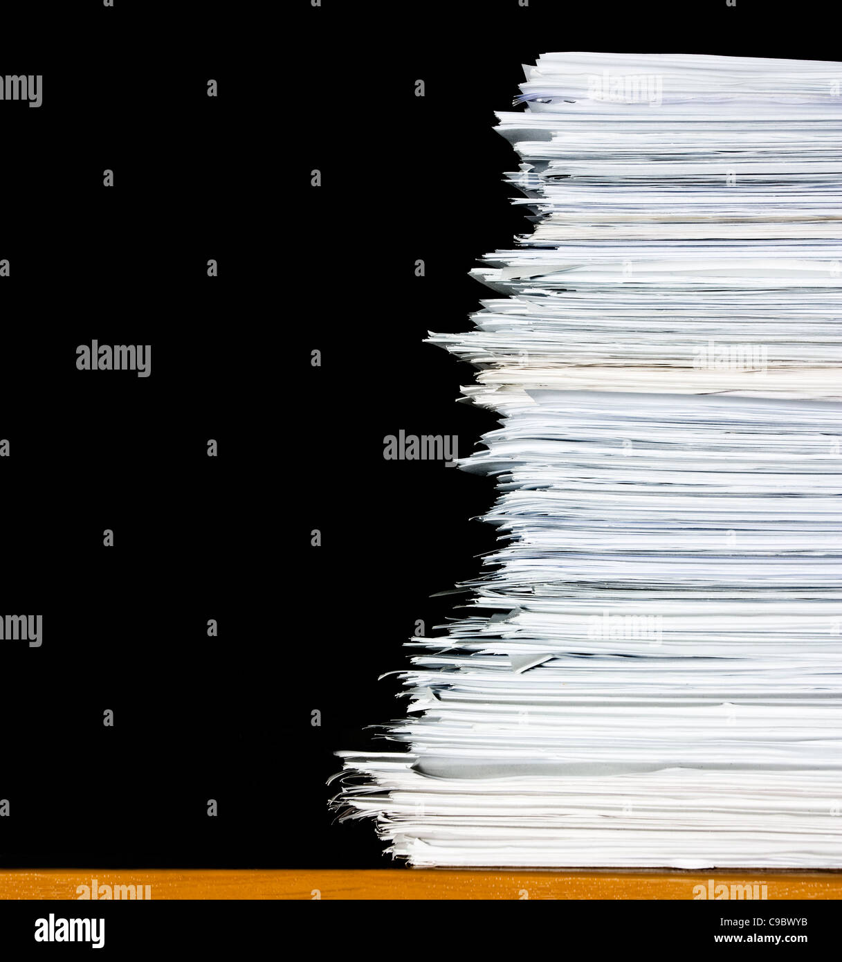 stack of documents or files on desk in office, overload of paperwork on black background, isolated on black background Stock Photo