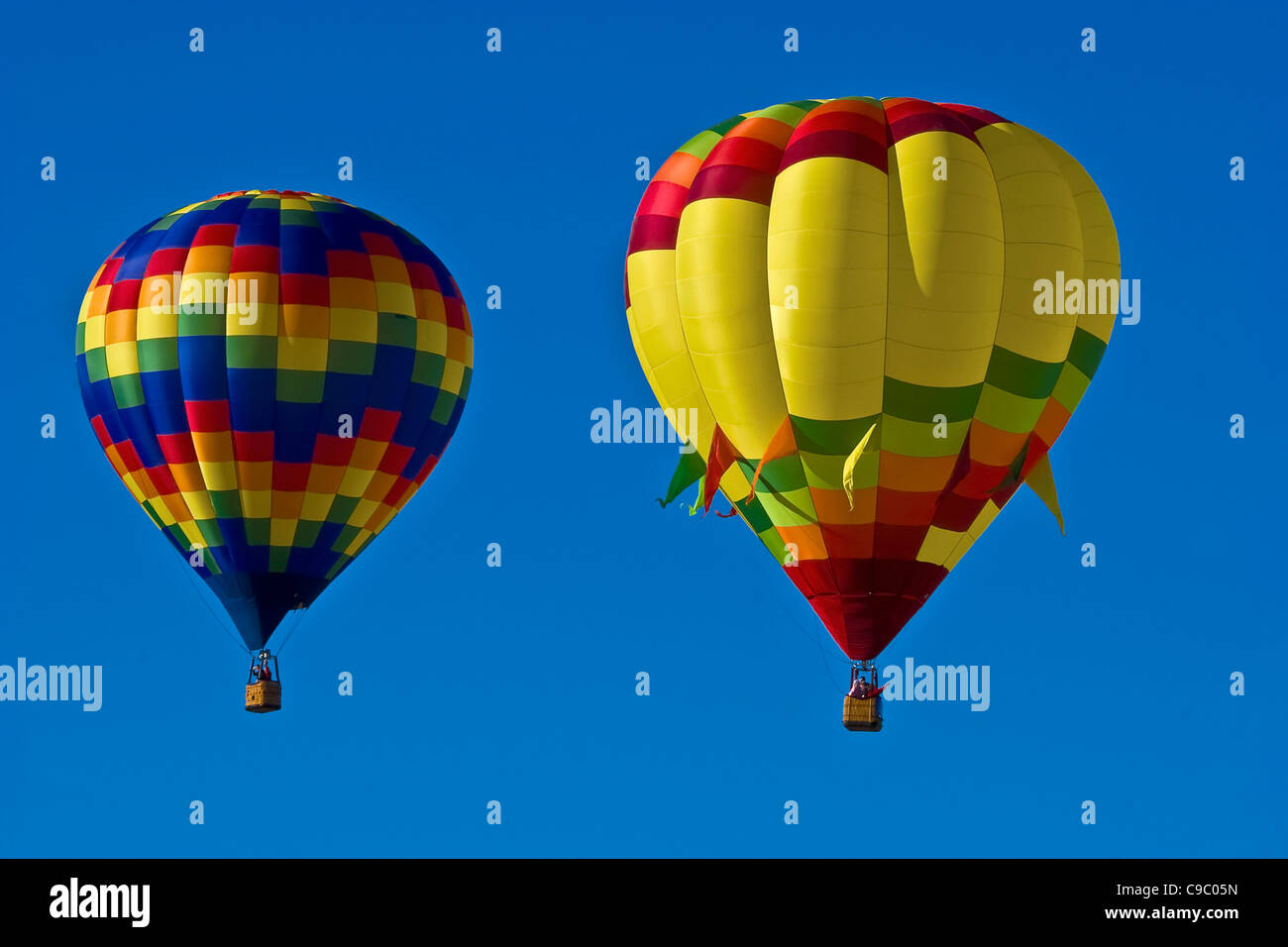 USA, New Mexico, Albuquerque, Balloon Festival. Two colourful hot air balloons in a clear blue sky. Stock Photo