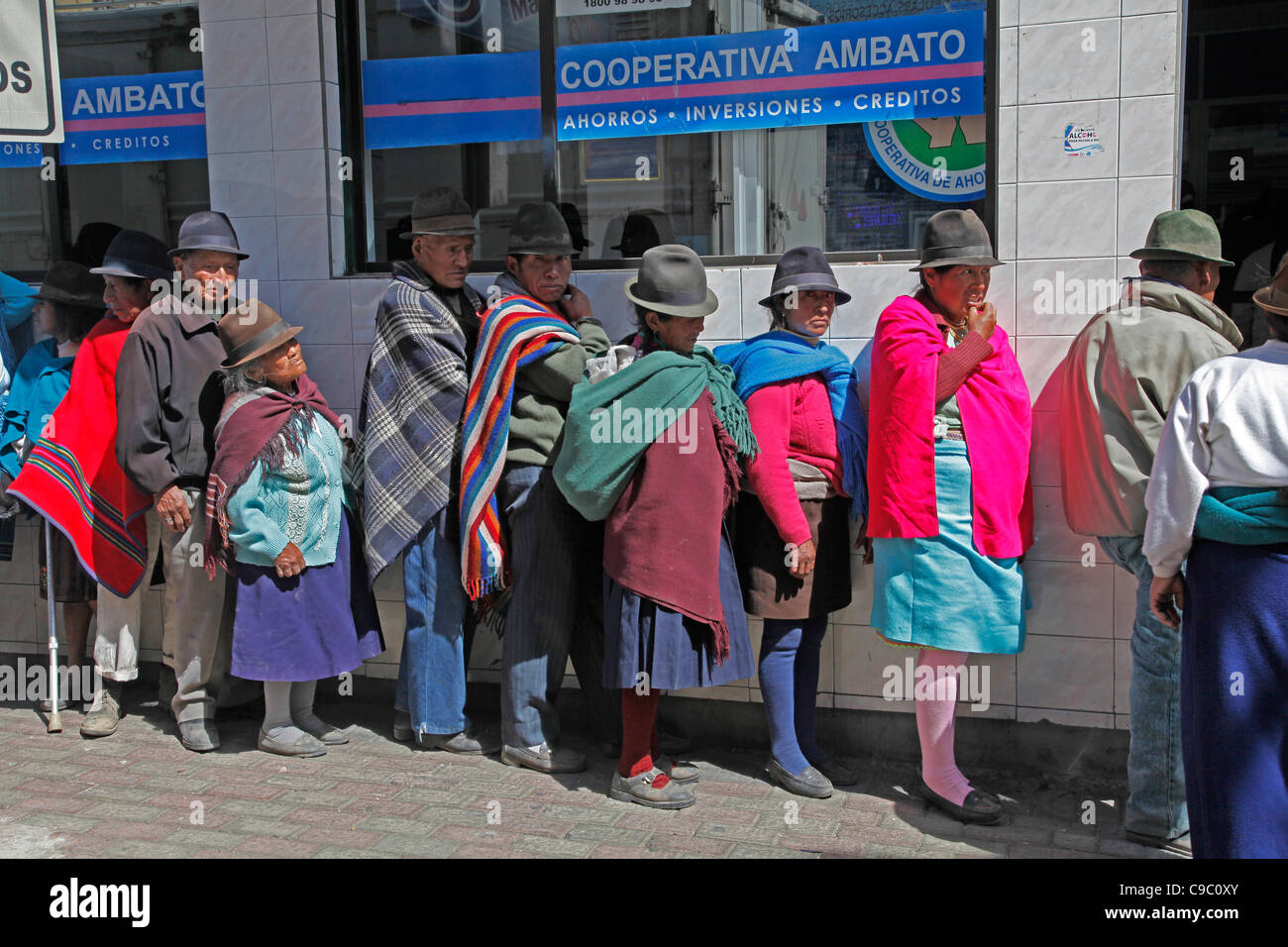 Ecuador. Native Quechua people queue outside bank in the streets of Ambato in the Andes region Stock Photo