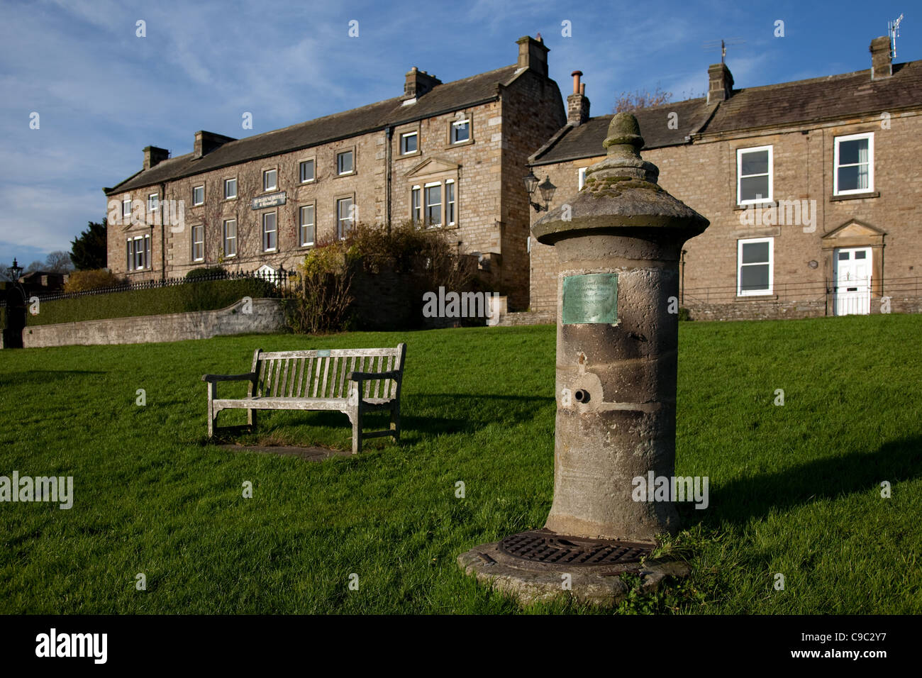 Stone Column Water Fountain and Hotel building in Reeth, Fremington And Healaugh, North Yorkshire, England Stock Photo