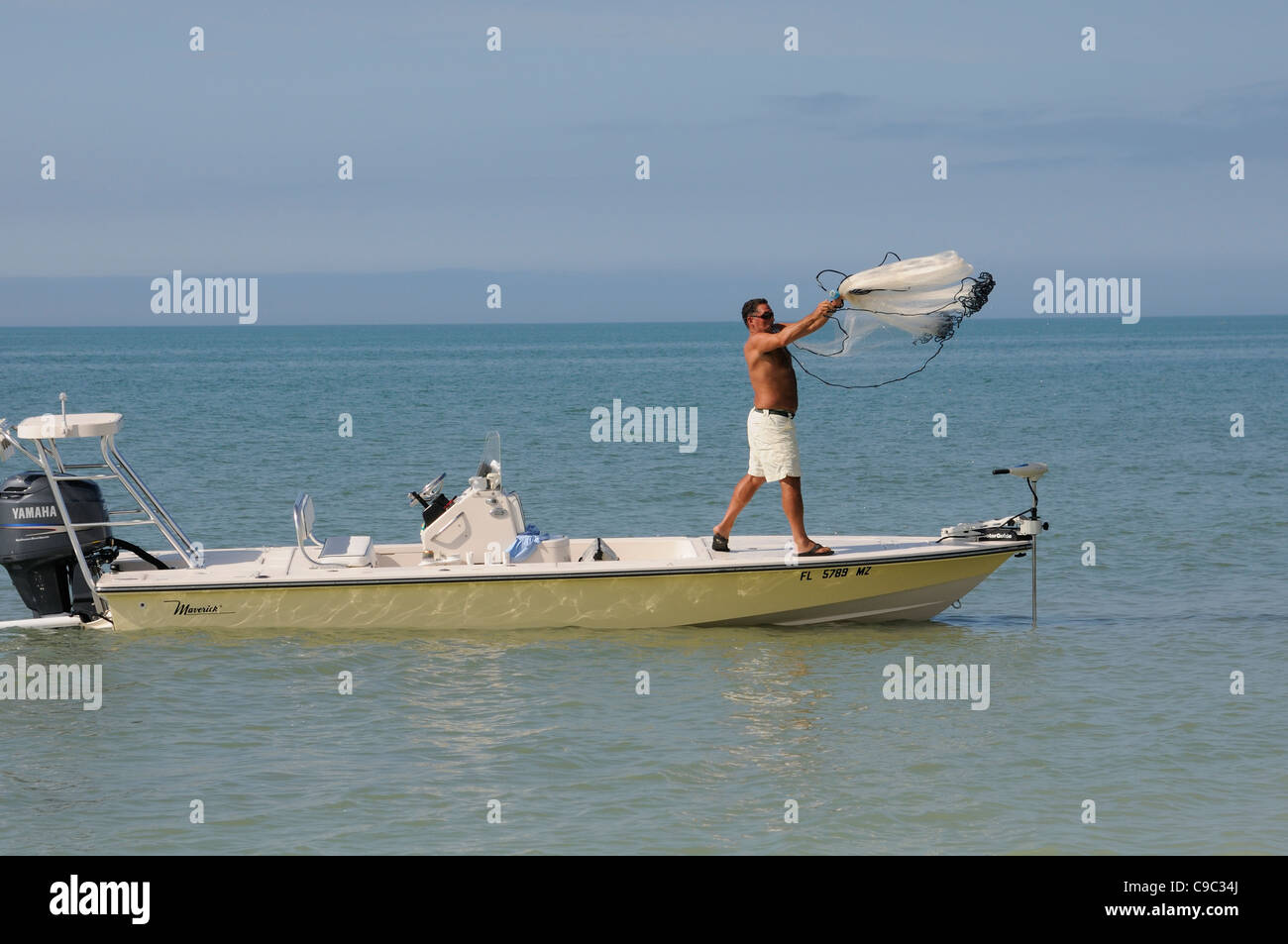 Man throwing a fishing net from a small boat on the Gulf Coast Florida USA  Fishing for bait Stock Photo - Alamy