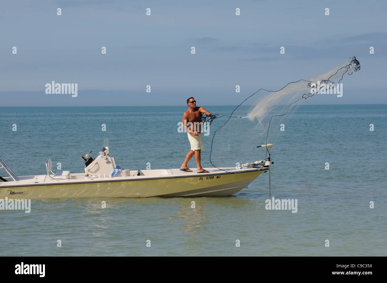 Man throwing a fishing net from a small boat on the Gulf Coast Florida USA  Fishing for bait Stock Photo - Alamy
