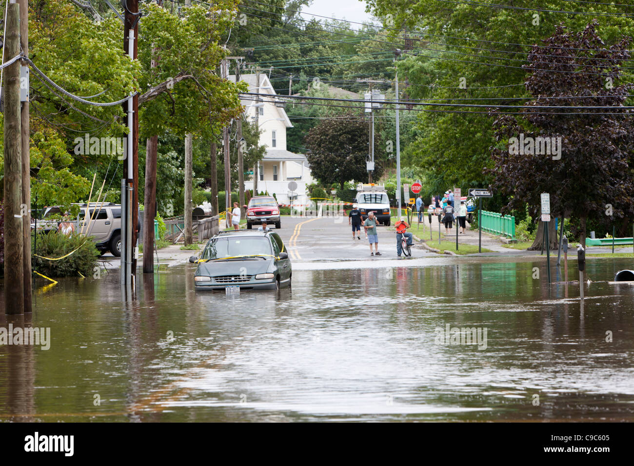 Local residents look at flooding on Jefferson Street in the aftermath of Hurricane Irene in Mamaroneck, New York. Stock Photo