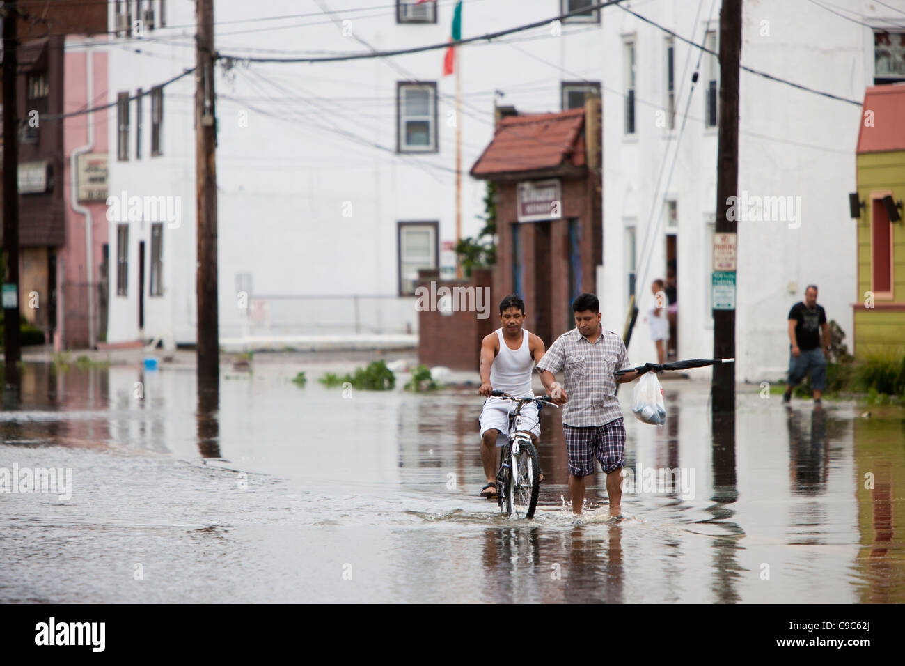 Local residents walk through high water on flooded Mamaroneck Avenue in