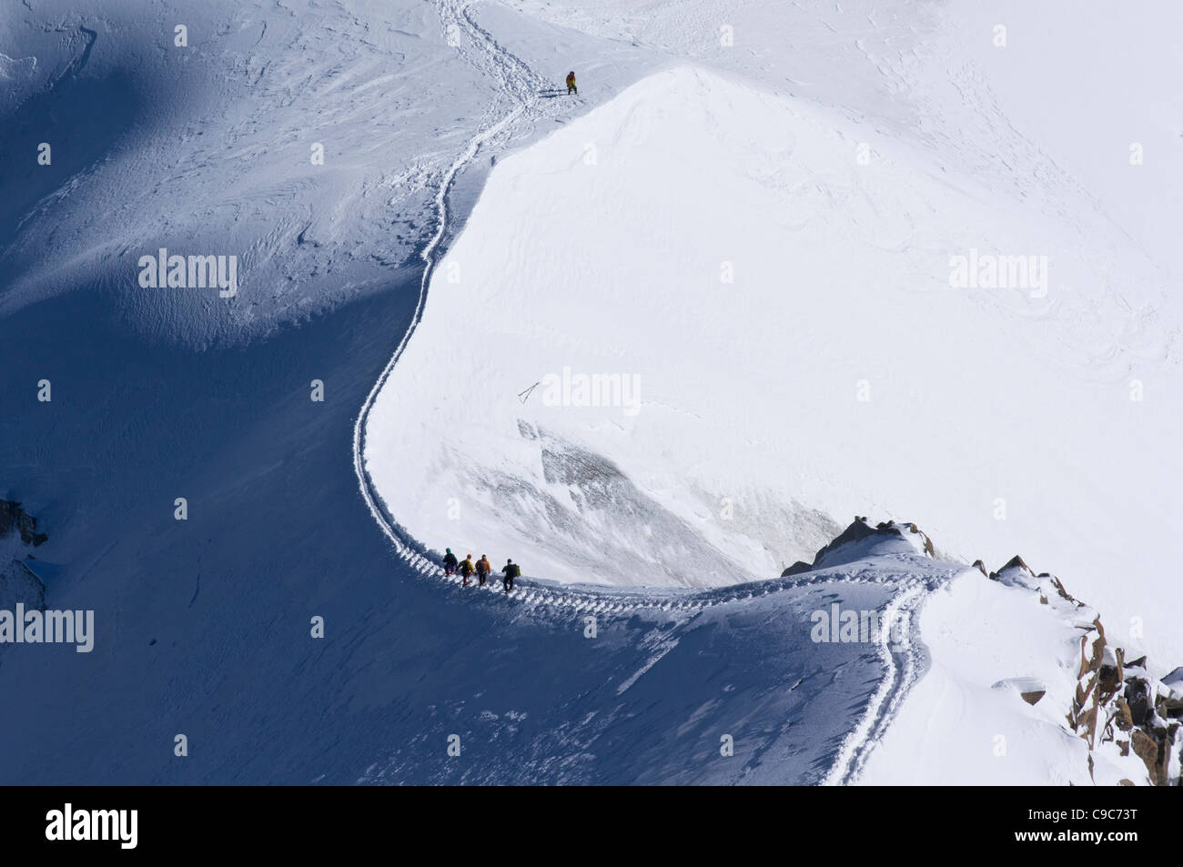 Climbers descend the ice steps cut into the arete from the Aiguille du Midi to the col de Plan Stock Photo