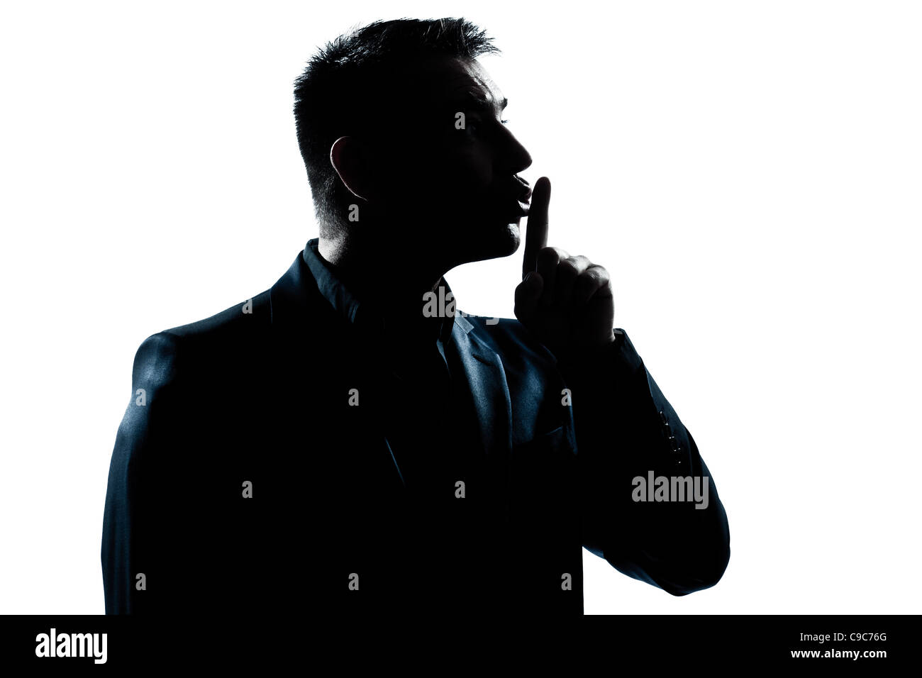 one  man hushing profile portrait silhouette in studio isolated white background Stock Photo
