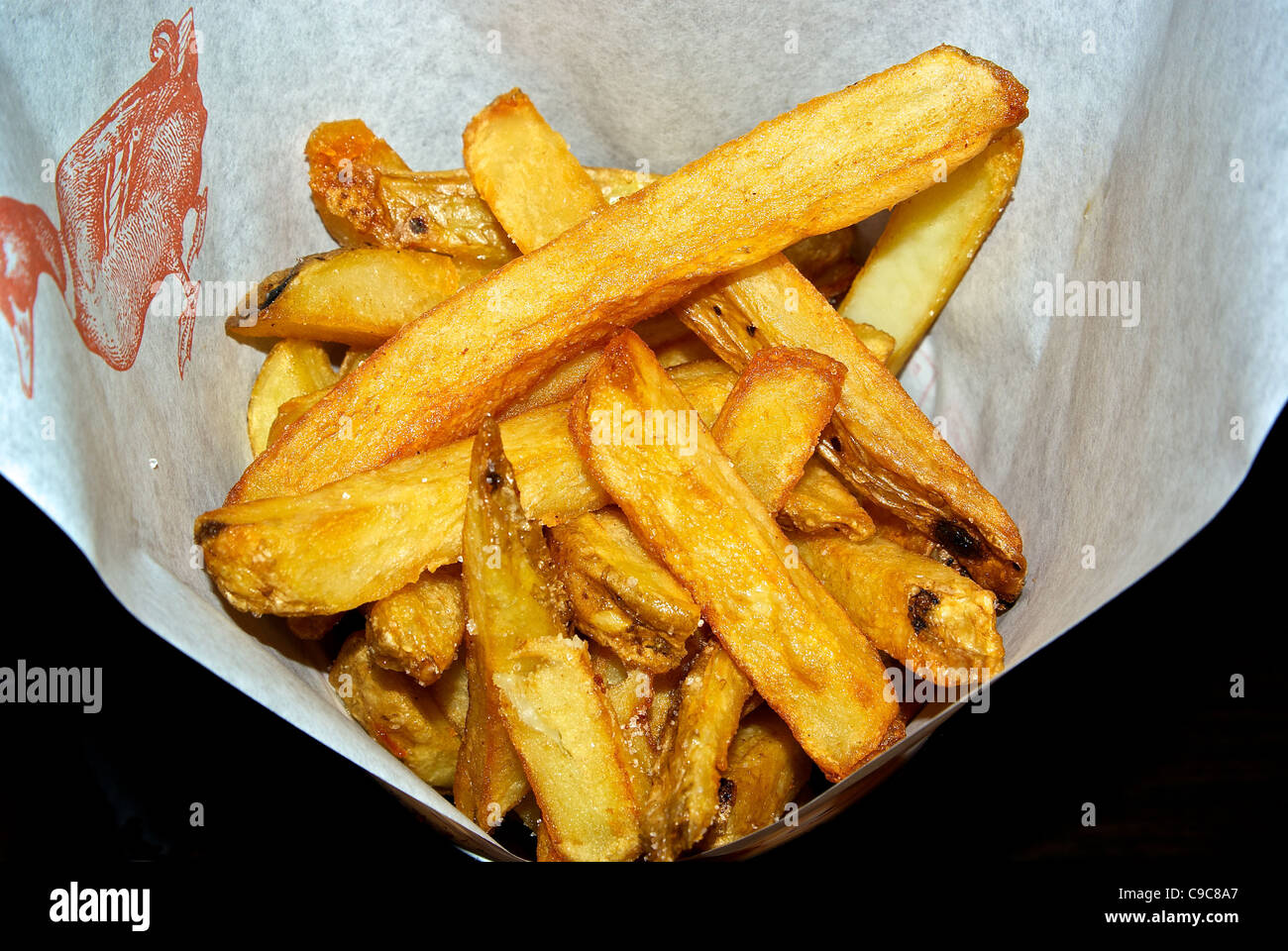 Pommes frites potato French fries fried in duck fat salted served in a paper cone Stock Photo