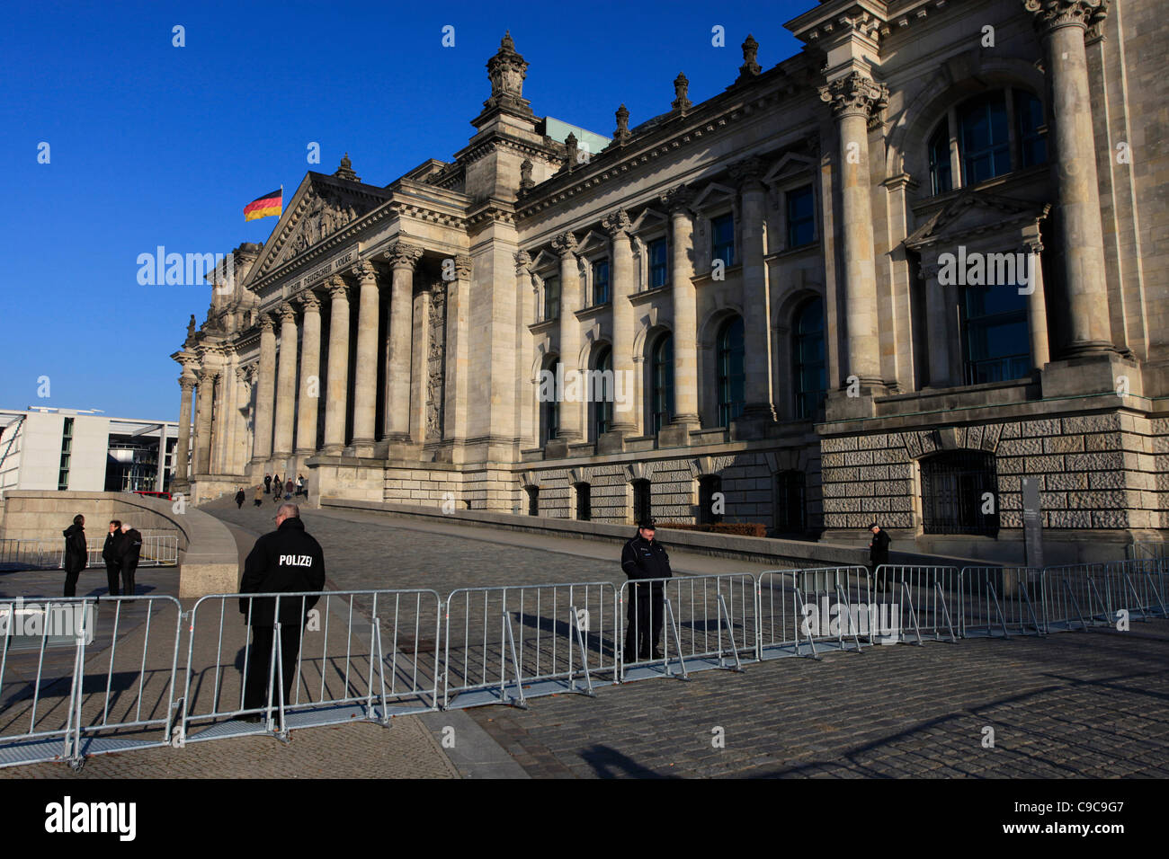 Policemen stand guard in front of the German Federal parliament Reichstag building seat of the Bundestag built in the neo-renaissance style in Berlin Germany Stock Photo