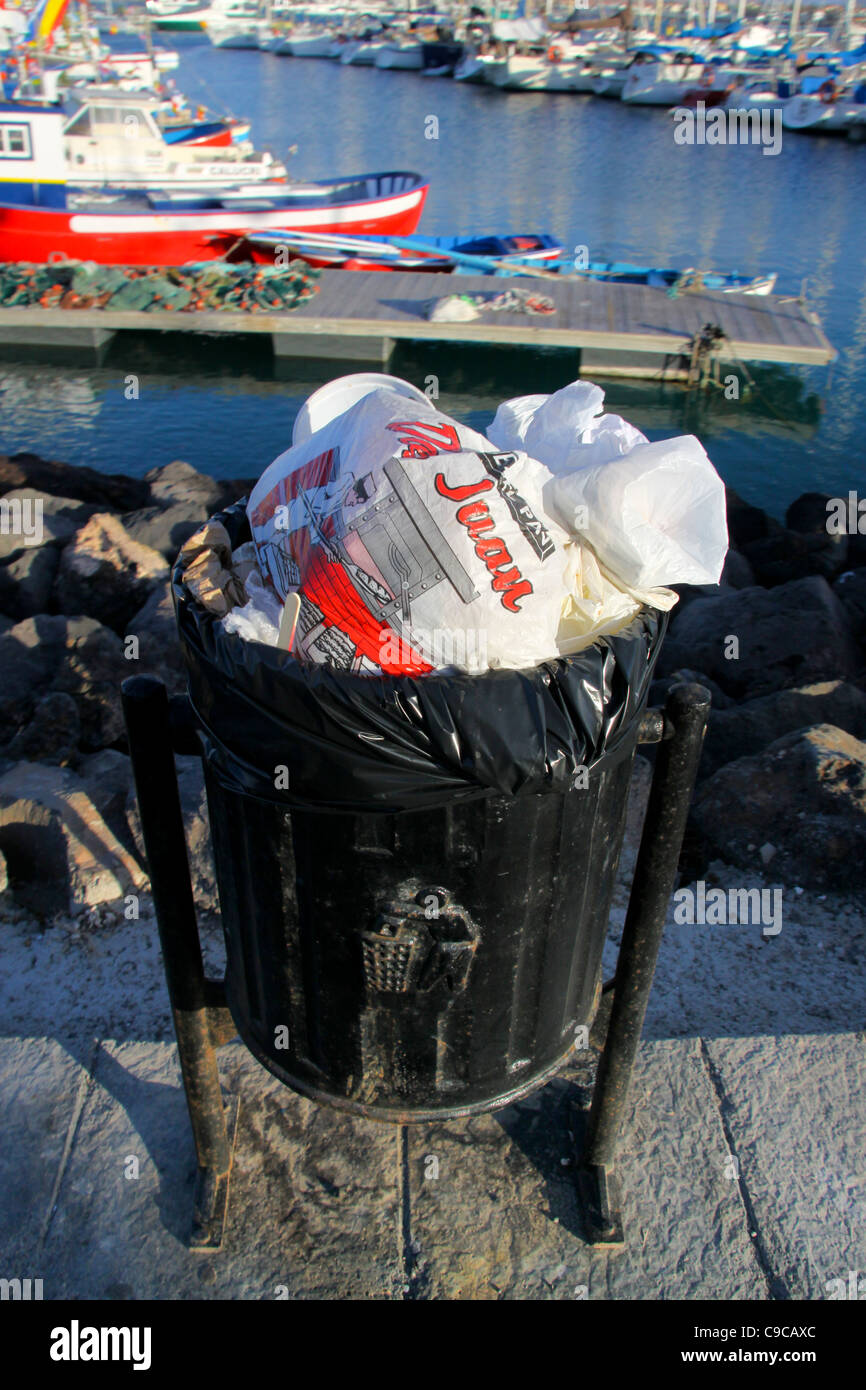 Waste bin full of rubbish at harbour Stock Photo