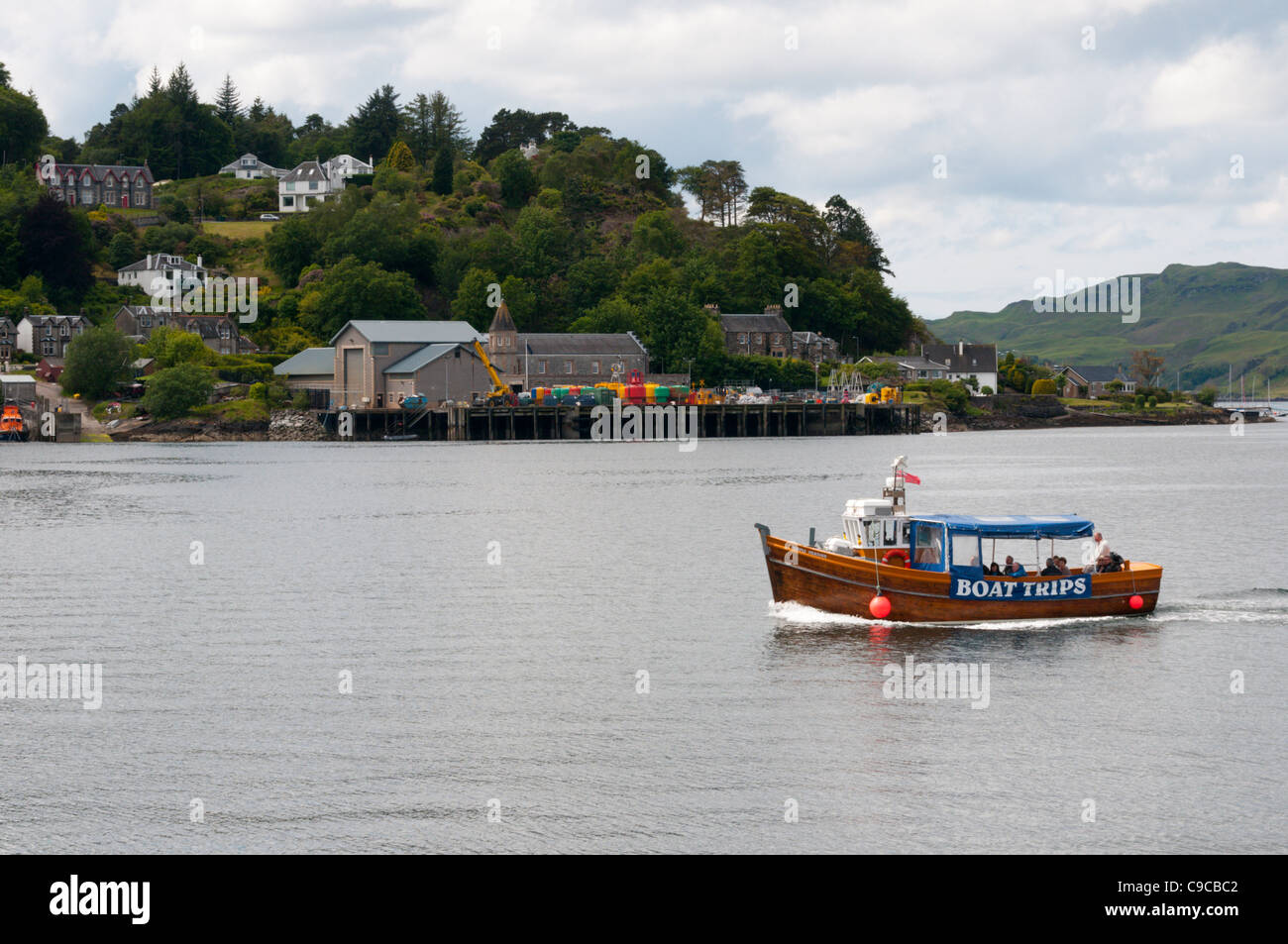 A small boat takes tourists for a trip around the harbour at Oban, Scotland Stock Photo