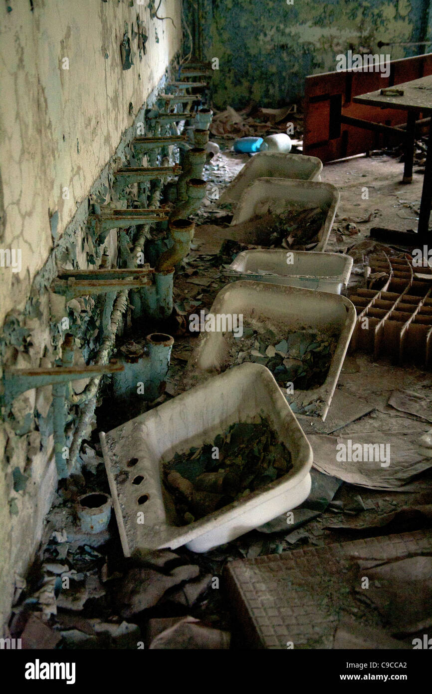 Wash basins pulled from the wall in the childrens toilets Pripyat Middle School Sportivnaya Street, Pripyat Chernobyl exclusion Stock Photo