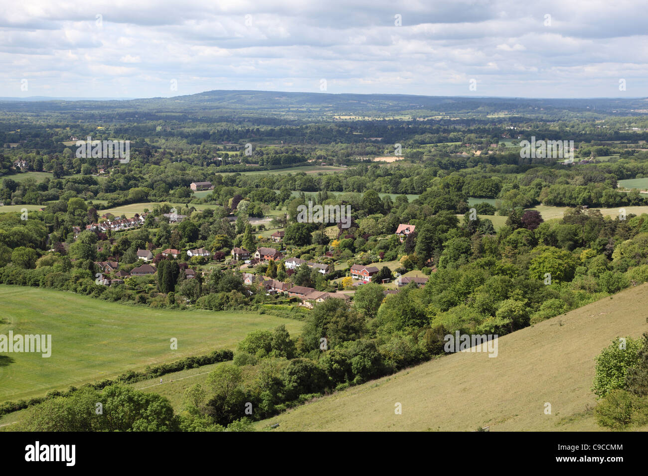 Houses in woodland near Reigate, Surrey, UK viewed from the North Downs looking across the Weald towards Sussex. Part of London's Green Belt. Stock Photo