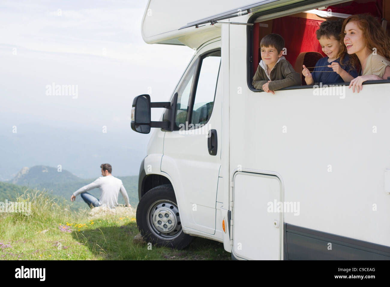 Mother and young boys looking out motor home window Stock Photo