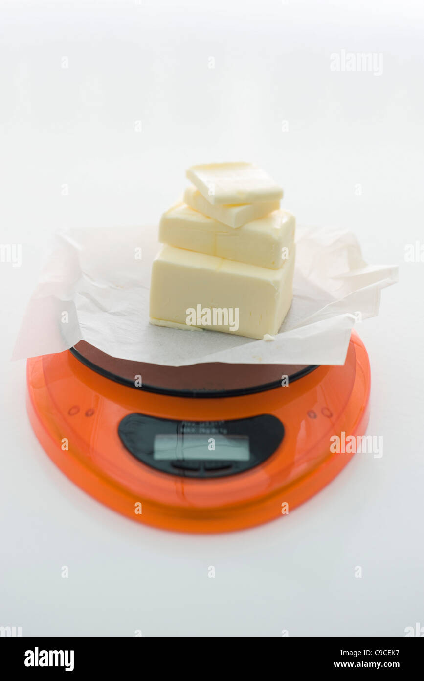 Weighing butter on kitchen scale Stock Photo