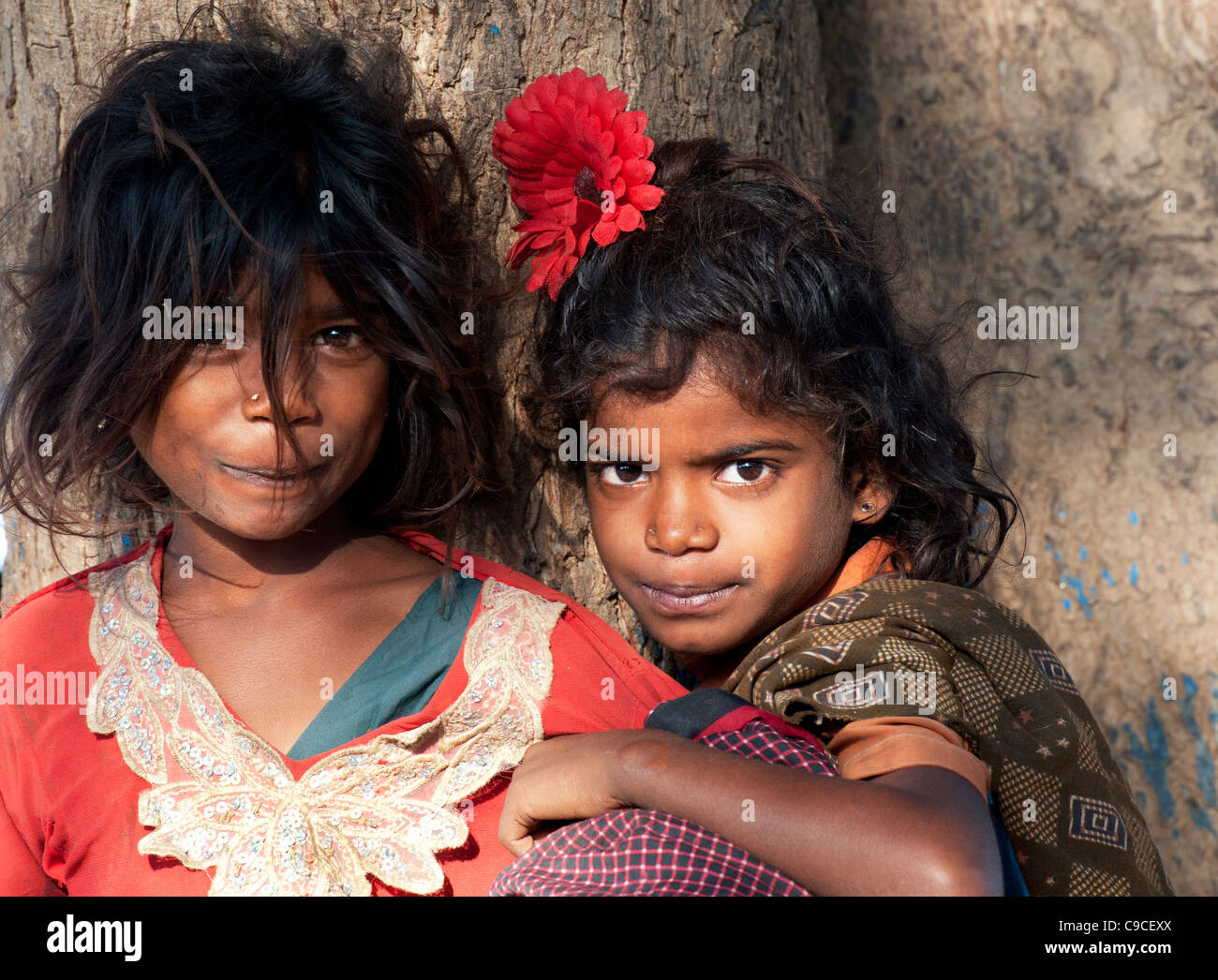 Happy Poor Indian nomadic beggar girls against a tree. Andhra Pradesh, India Stock Photo
