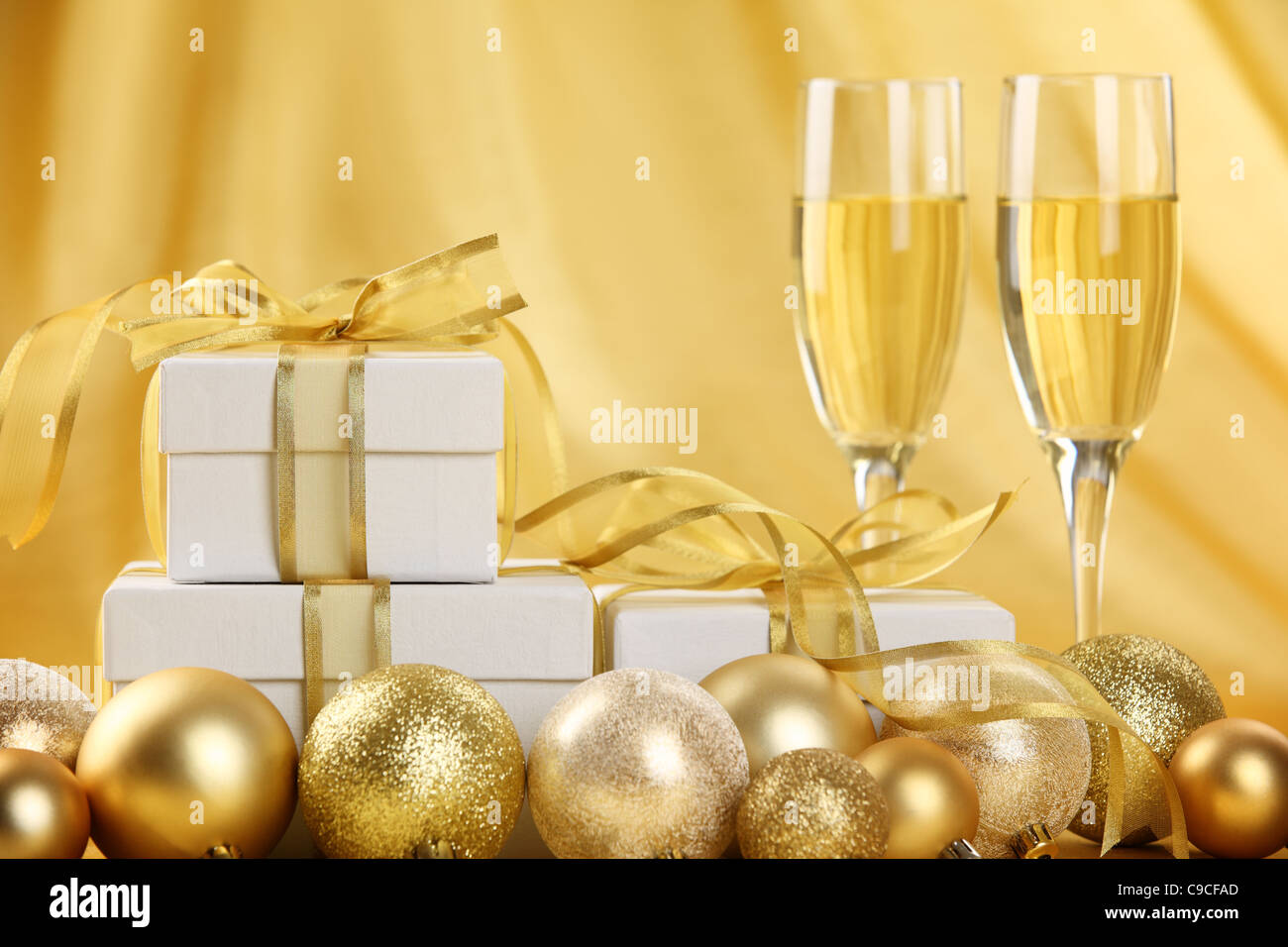 Glasses of champagne with gift boxes and Christmas balls. Stock Photo