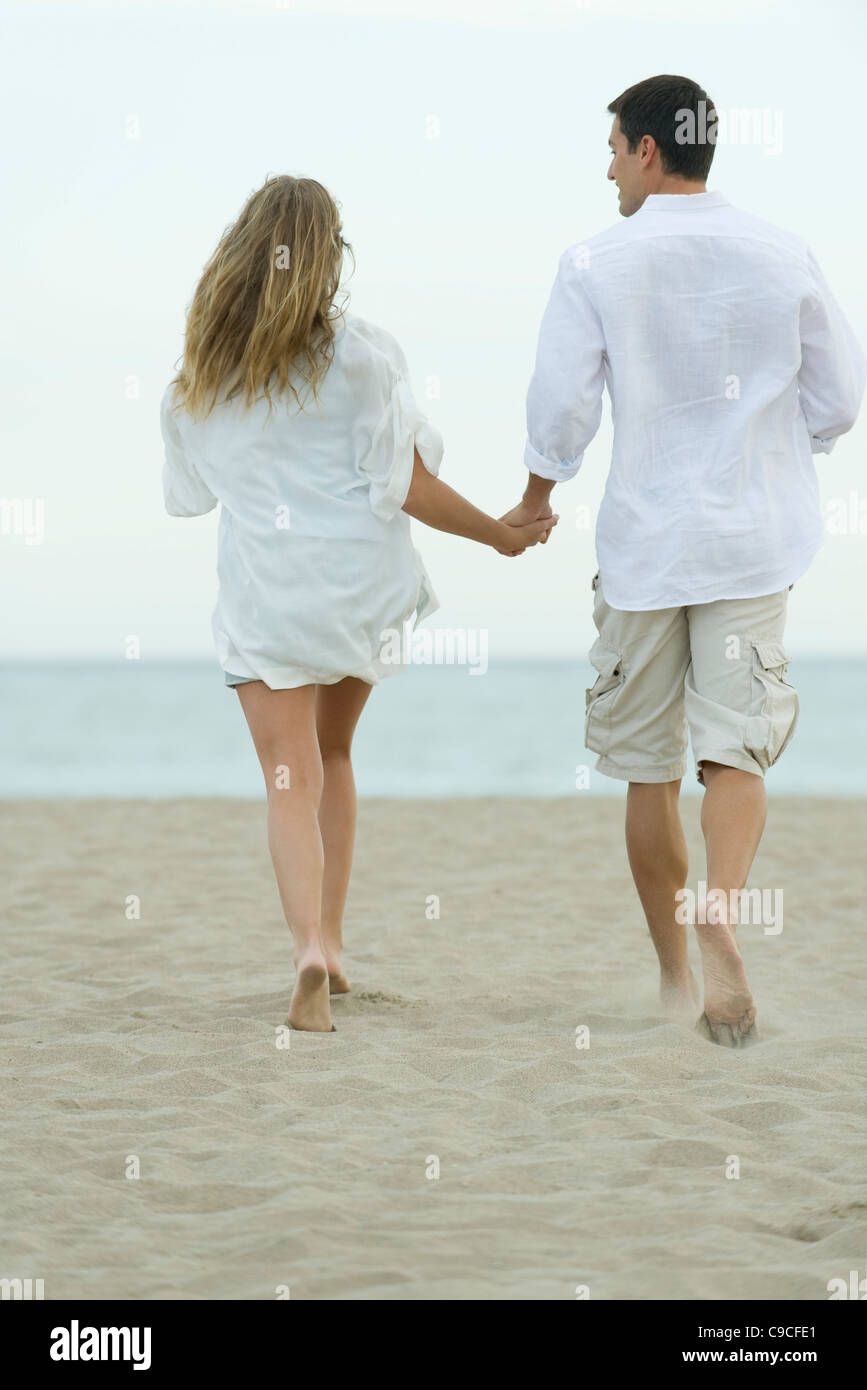 Couple walking together on beach, rear view Stock Photo Alamy
