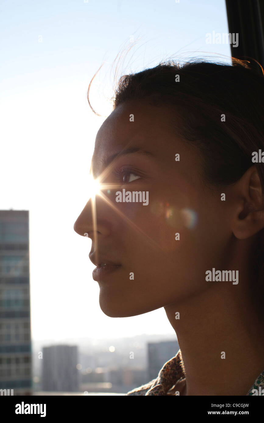 Silhouette of woman's face, sunshine in background Stock Photo