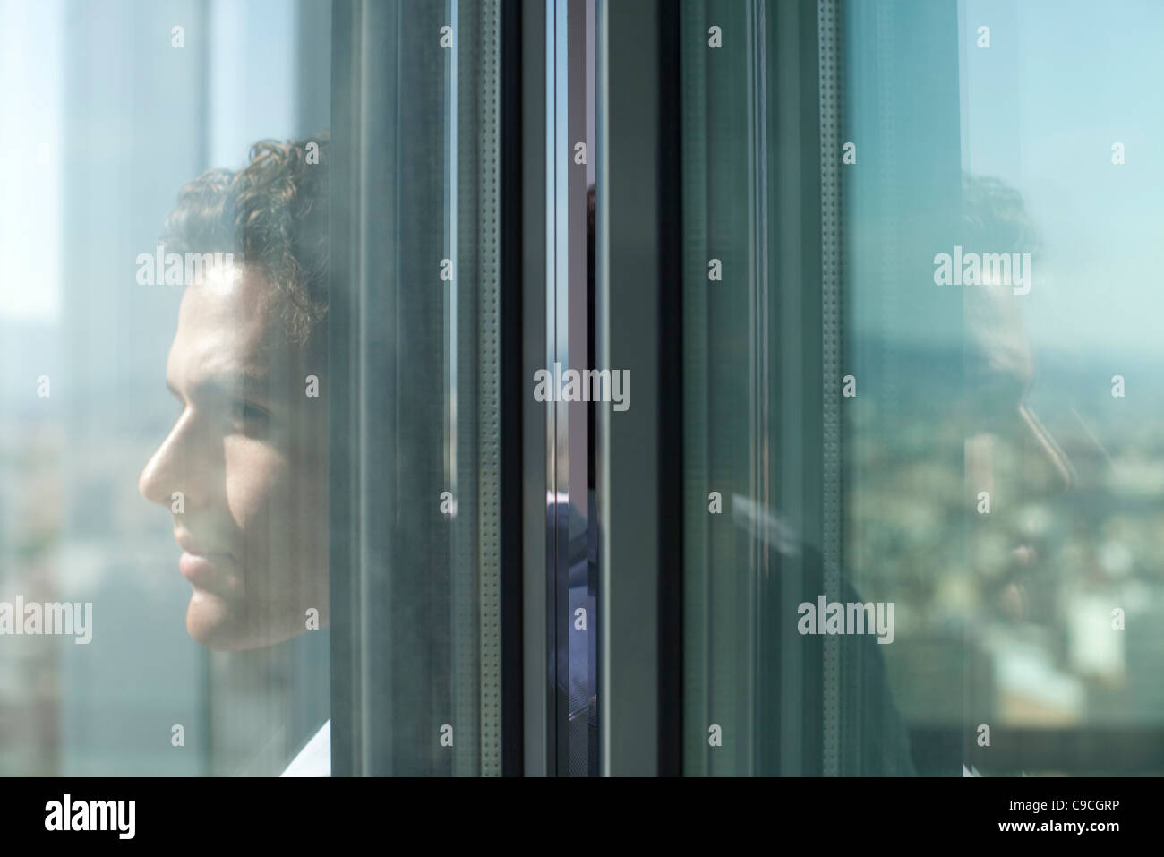 Man looking out of open window Stock Photo - Alamy