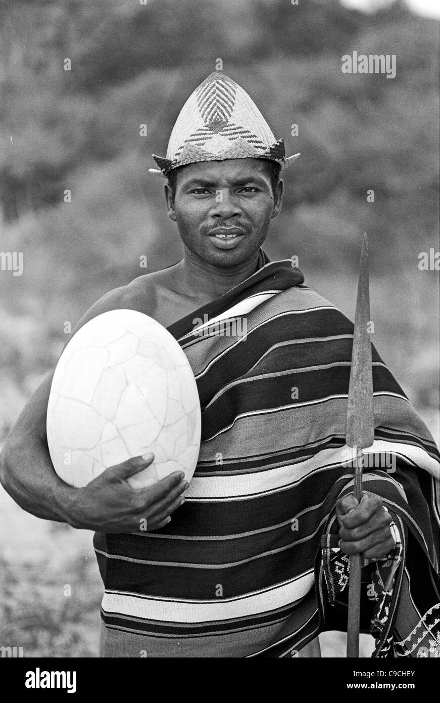 Antandroy Man Poses in Traditional Lamba Dress or Costume with Spear and Giant Elephant Bird Egg, Aepyornis maximus, near Ampanihy southern Madagascar Stock Photo