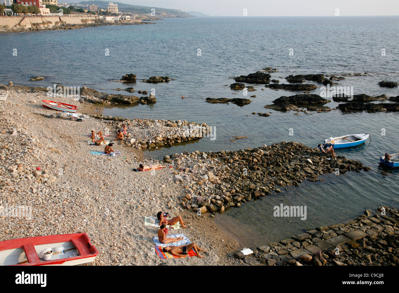 People on the beach just by the city walls, Alghero, Sardinia, Italy. Stock Photo