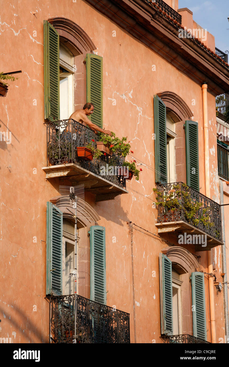 Men standing at his house balcony, Bosa, Sardinia, Italy. Stock Photo