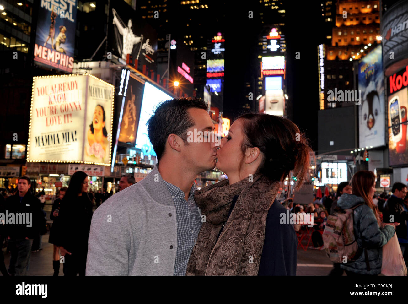 Young attractive couple kissing at night in Times Square Manhattan New York NYC USA America Stock Photo
