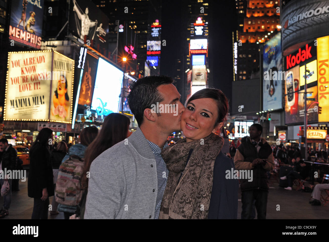 Young attractive couple kissing at night in Times Square Manhattan New York NYC USA America Stock Photo