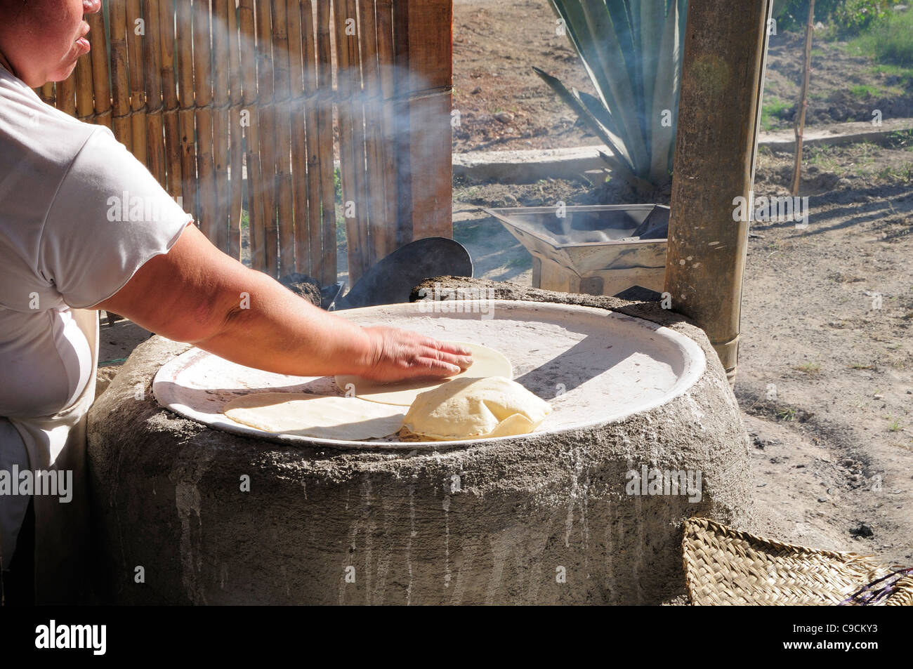 https://c8.alamy.com/comp/C9CKY3/mexico-oaxaca-woman-making-tortillas-outside-on-traditional-comal-C9CKY3.jpg