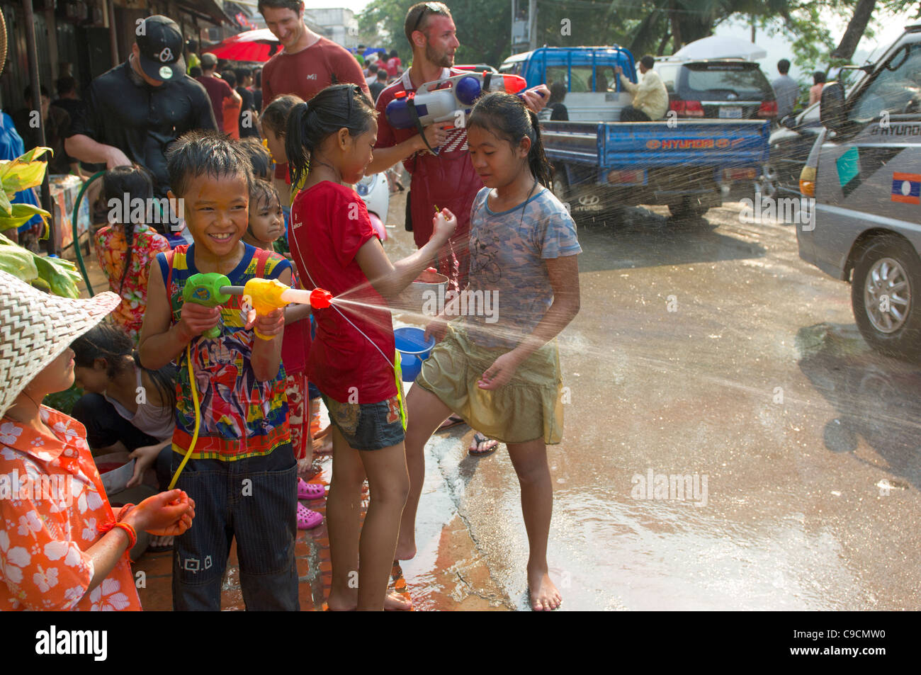 Young Lao boy with super-soaker taking part in water fight, Lao New Year (Pi Mai Lao), Luang Prabang, Laos Stock Photo