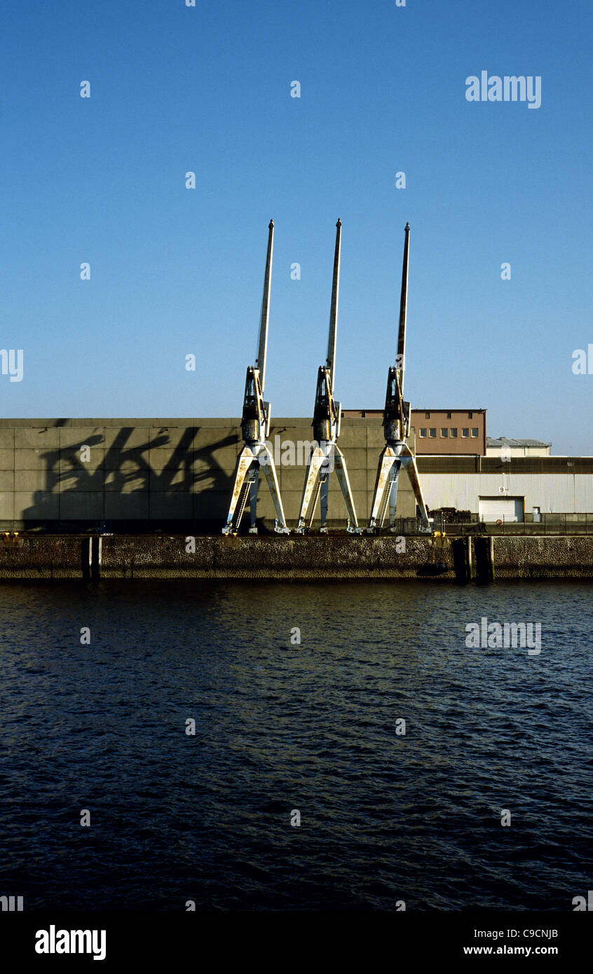 Old gantry cranes casting shadows in the morning light at Kaiser-Wilhelm-Hafen in the port of Hamburg. Stock Photo