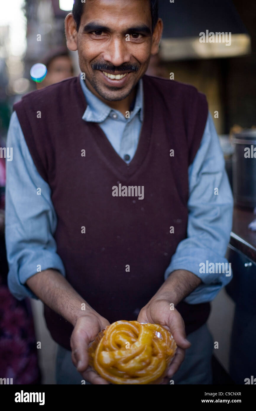 A man holds jalebis at the Old & Famous Jalebi Wala (at the corner of Dariba Kalan and Chandni Chowk). Delhi, India Stock Photo