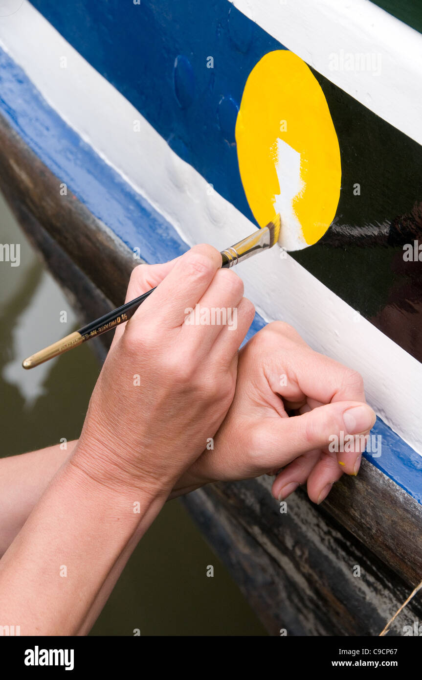 Painting the detail on a narrowboat Stock Photo Alamy