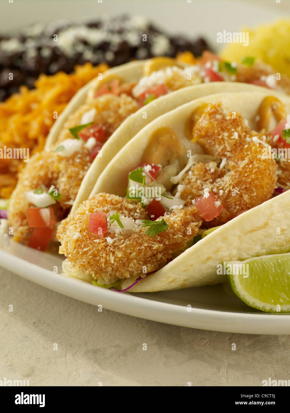Two fried shrimp tacos served with Spanish rice and black beans Stock Photo