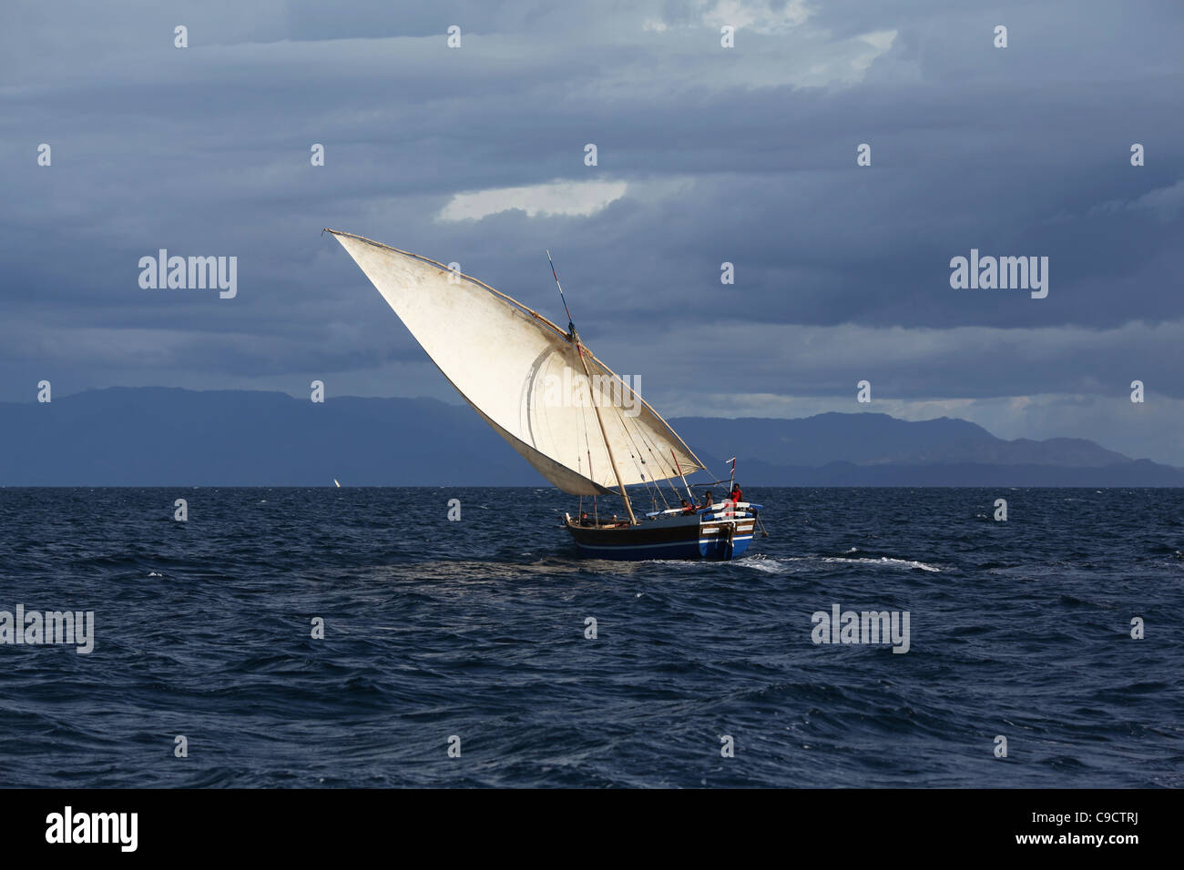 A traditional malagasy sailing vessel, or boutre, with a full sail off Mamoko island in north-western Madagascar, near Nosy-Be. Stock Photo