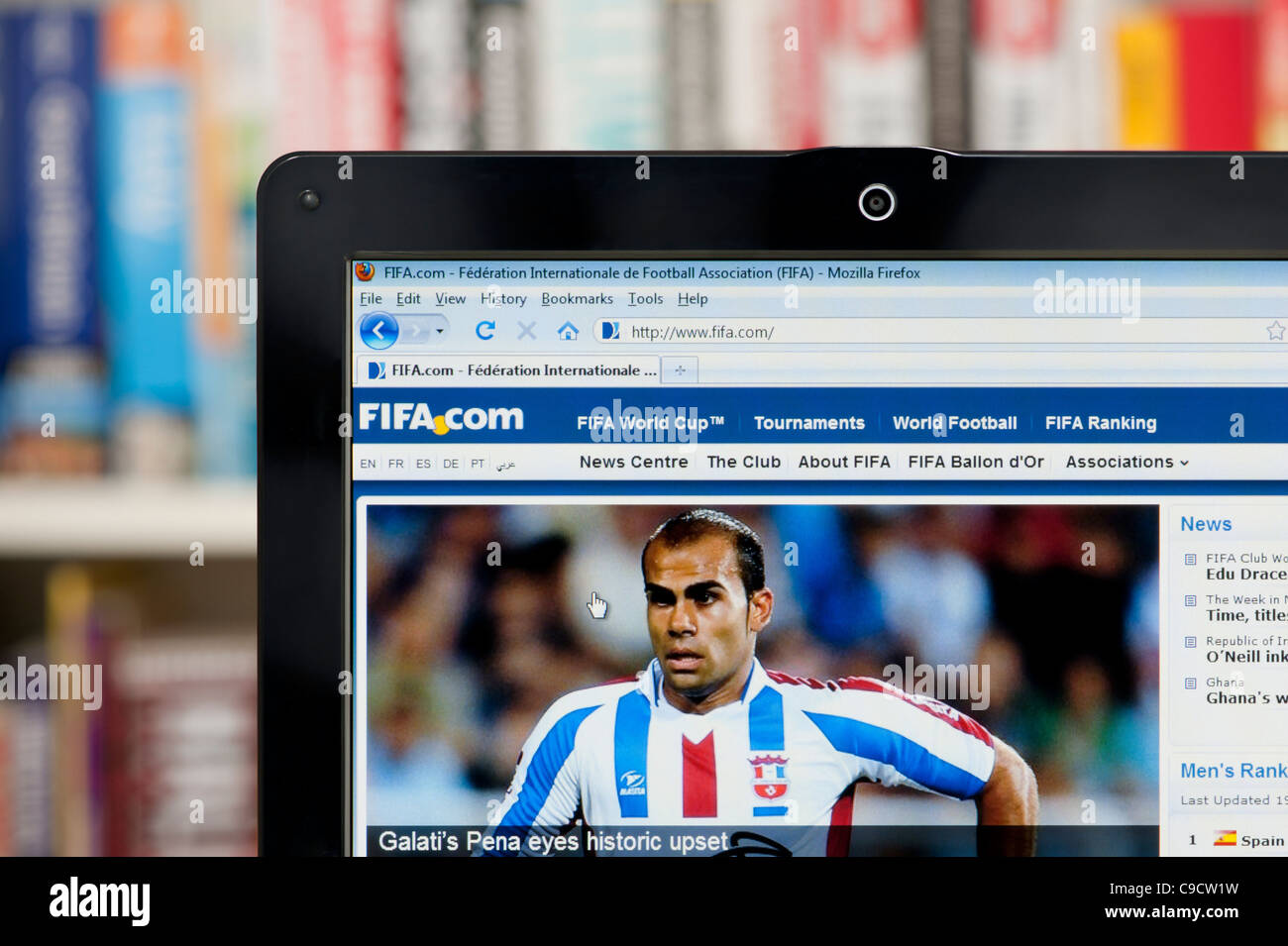 The FIFA website shot against a bookcase background (Editorial use only: print, TV, e-book and editorial website). Stock Photo