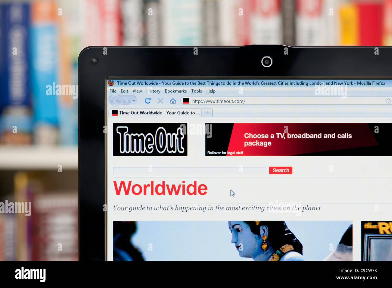 The Time Out Worldwide website shot against a bookcase background (Editorial use only: print,TV, e-book and editorial website). Stock Photo
