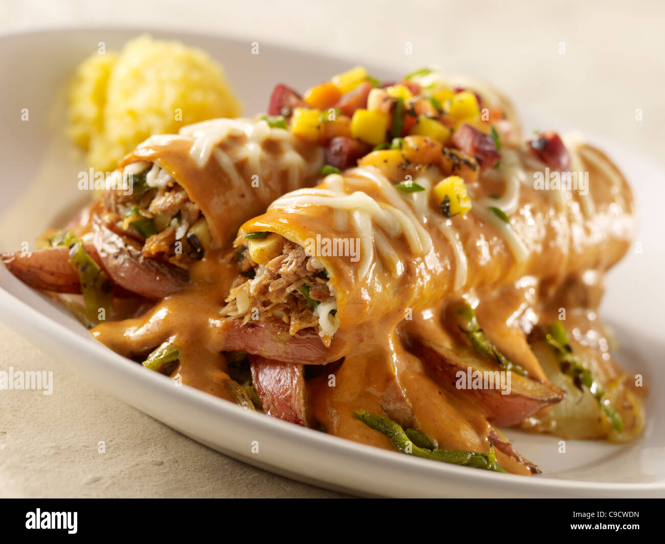 Two pulled pork enchiladas smothered in sauce, cheese and a pineapple