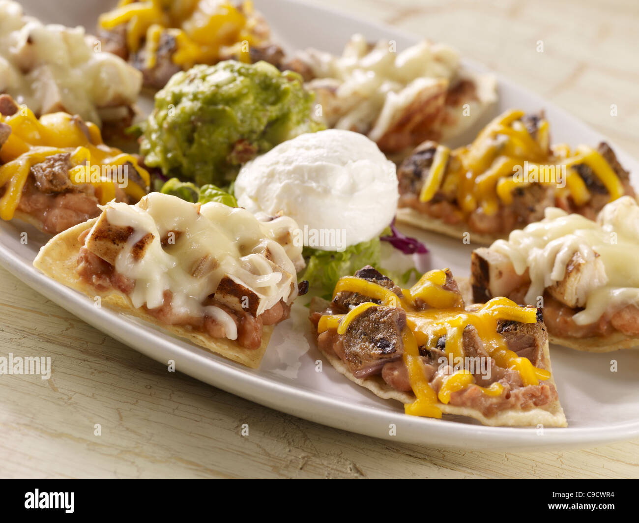 Fajita nachos combo topped with sour cream and guacamole Stock Photo