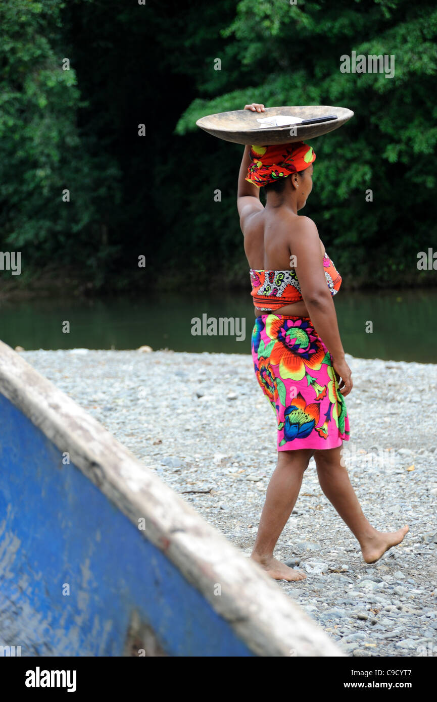 Embera indian woman carrying a plate of food on the head in the Chagres river in Panama at the embera puru amerindian community Stock Photo